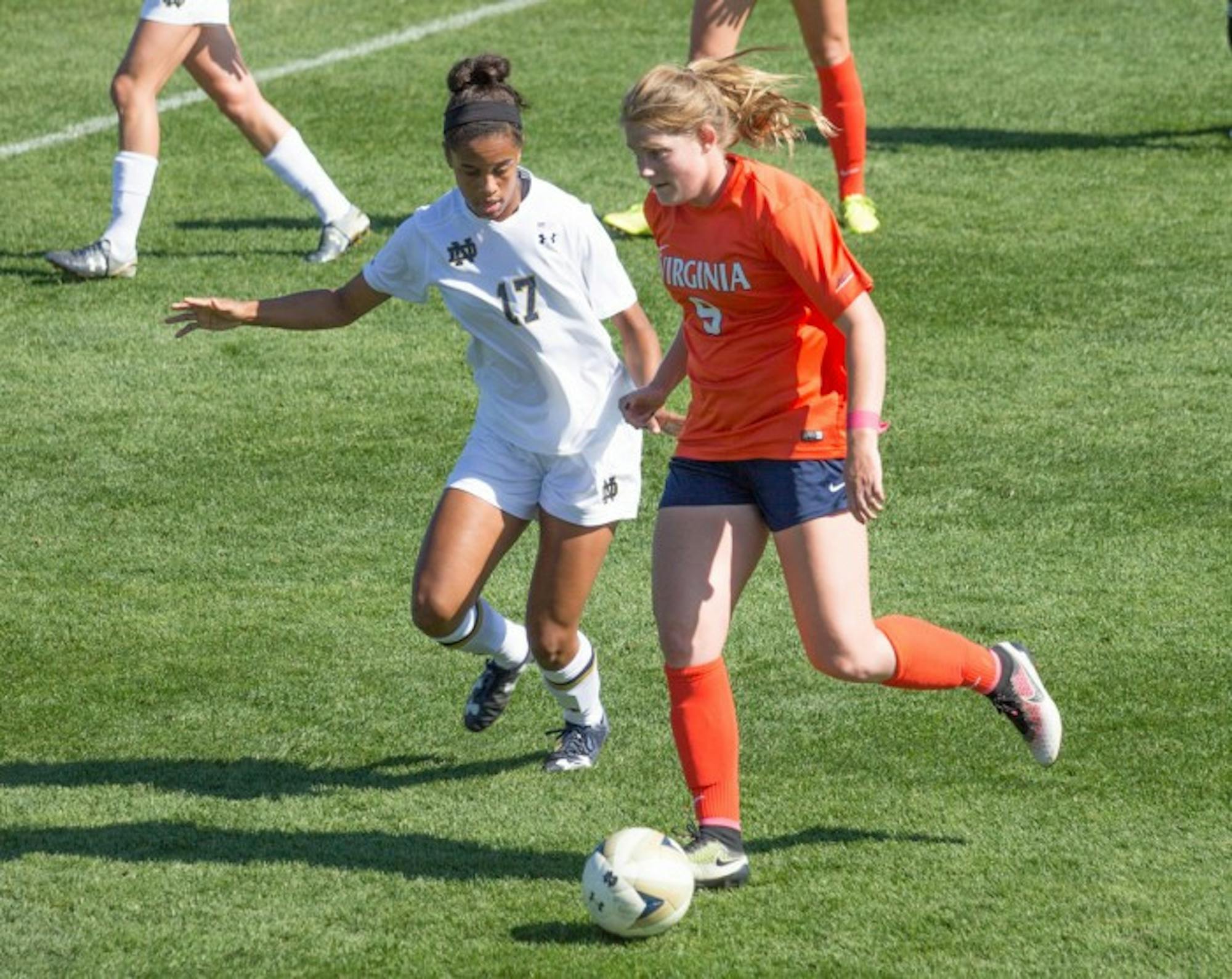 Senior midfielder Sandra Yu holds off a Virginia defender on Oct. 9. The Irish can share the ACC title with a win against Miami.
