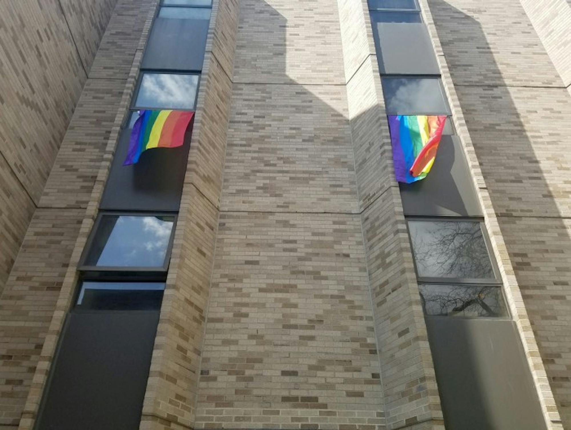 LGBT flags hang out the windows of a residence hall as a protest against Vice President Pence's upcoming Commencement speech.