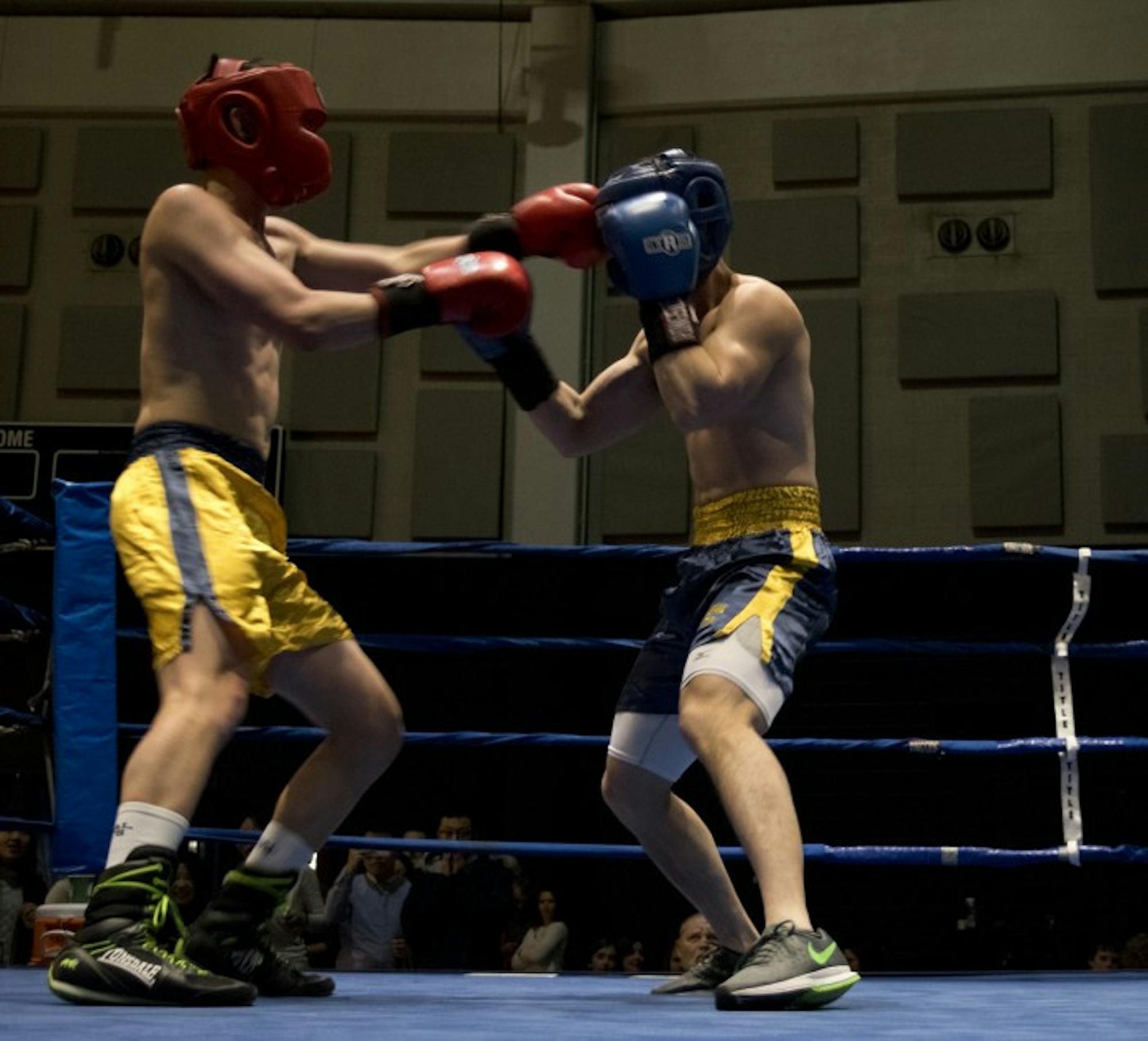 Senior Liam “Trooper” Chan, gold, lands a shot to the head of graduate student Qinfeng Wu during Bengal Bouts action Sunday at the JACC.