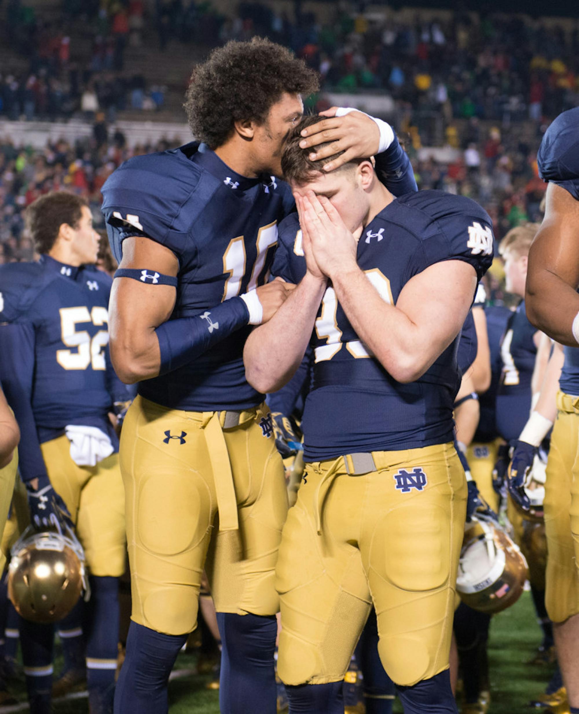 Irish sophomore safety Max Redfield, left, consoles senior running back Cam McDaniel following Notre Dame’s 31-28 loss to Louisville on Saturday at Notre Dame Stadium.