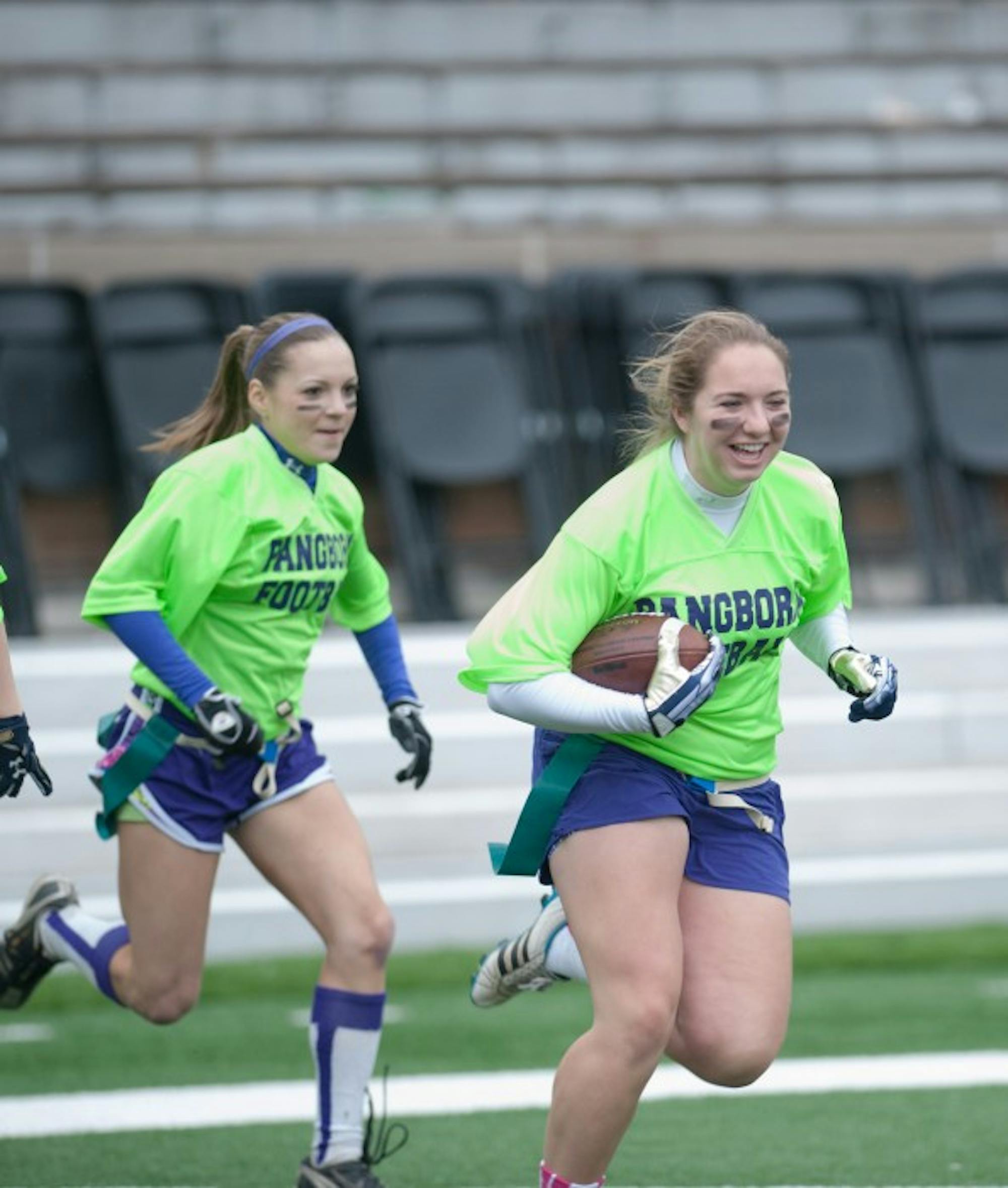 Pangborn seniors Katie Schultz, left, and Gracie Gallagher run onto the field before last year’s interhall championship game.