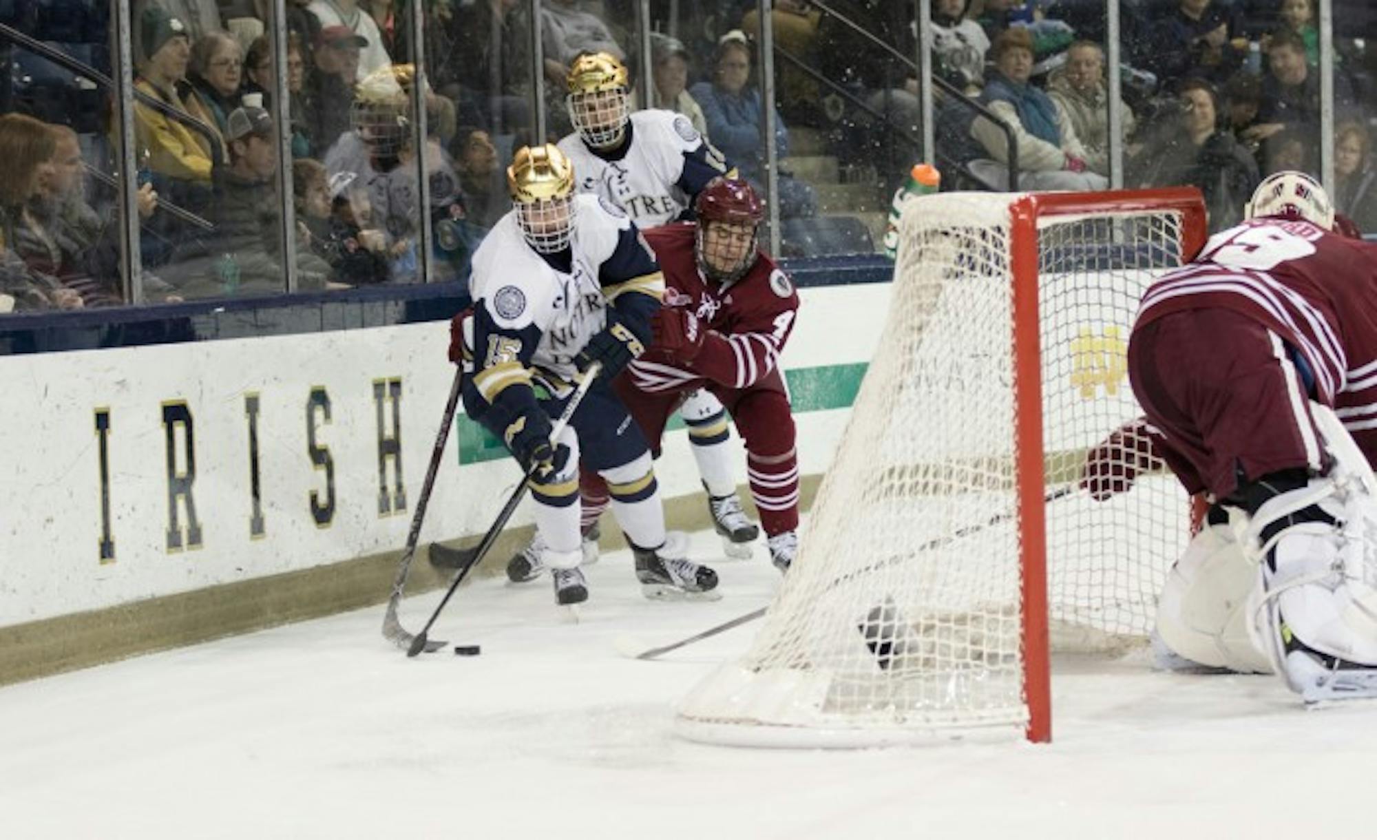 Centers  Andrew Oglevie and Jake Evans fight for the puck during Notre Dame’s 5-1 victory over Massachusetts on Sunday.