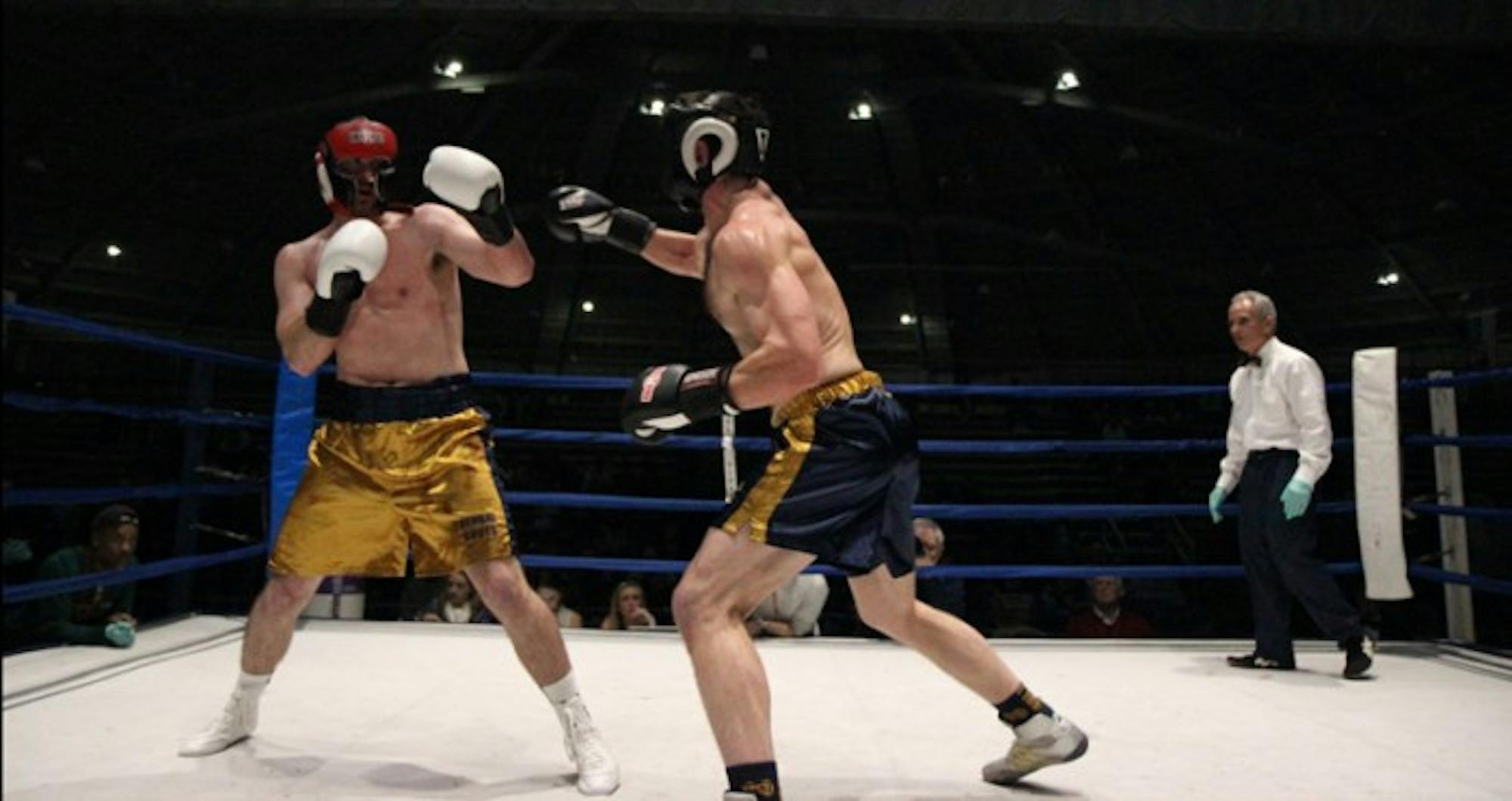 Captain and law student Brian Ellixson, right, lands a jab despite the best efforts of junior Ryan Lindquist to get out of the way.  Ellixson and Lindquist clashed in the semifinal round Tuesday night in the Joyce Center Fieldhouse. Ellixson took the victory by unanimous decision and advanced to the finals Sunday.