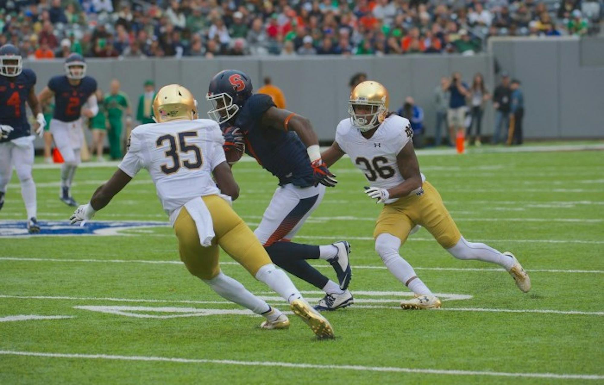 Freshman cornerback Donte Vaughn, left, and senior cornerback Cole Luke make look to tackle the ball carrier in Notre Dame's 50-33 victory over Syracuse at MetLife Stadium.