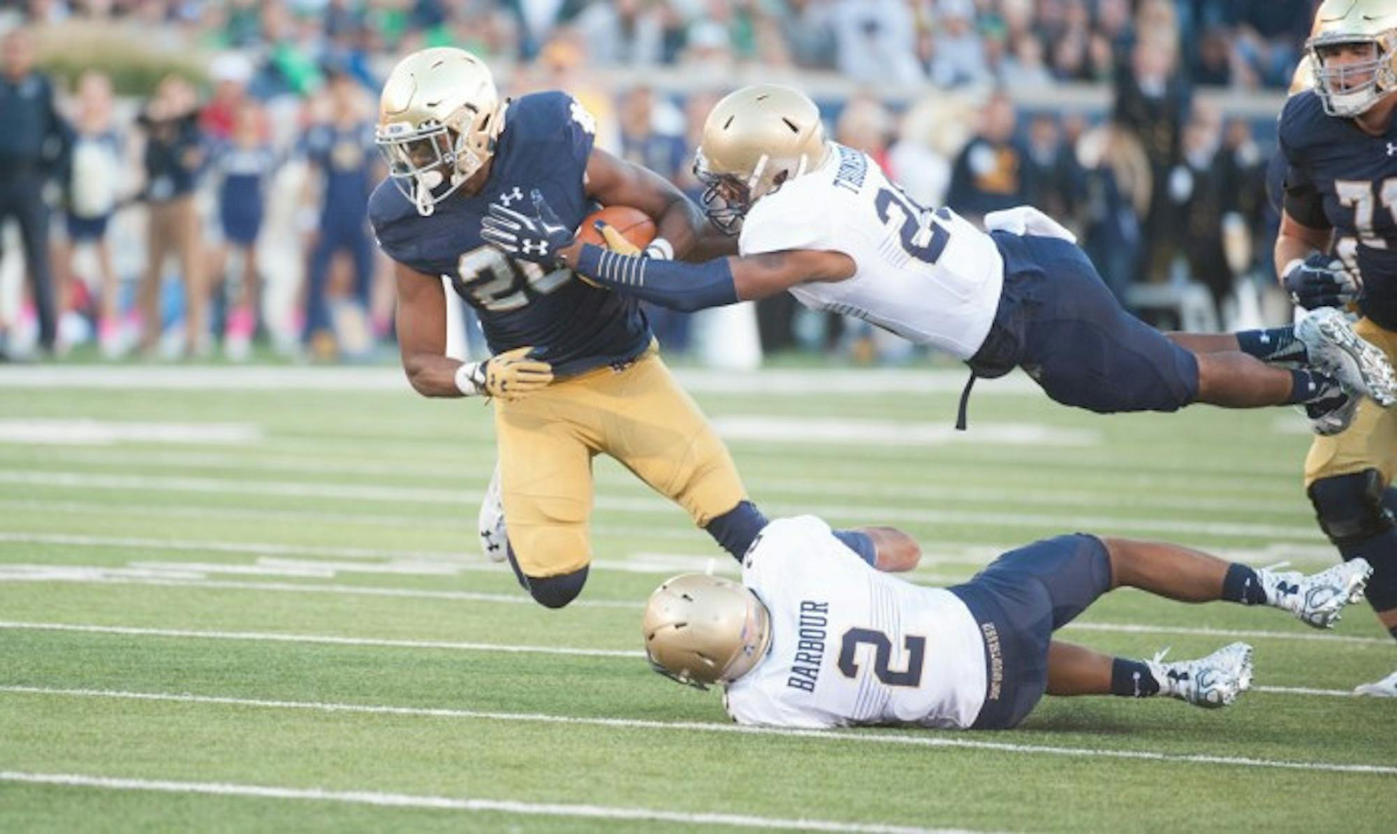 Senior running back C.J. Prosise attempts to evade two defenders during Notre Dame’s 41- 24 victory over Navy on Saturday.