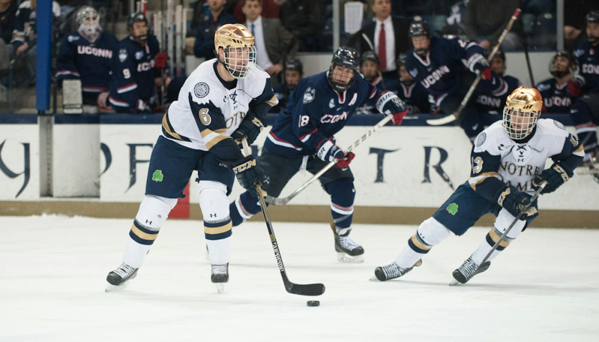 Irish junior defenseman Andy Ryan (left) pushes the puck up the ice in Notre Dame’s 3-3 tie with Connecticut on Friday.