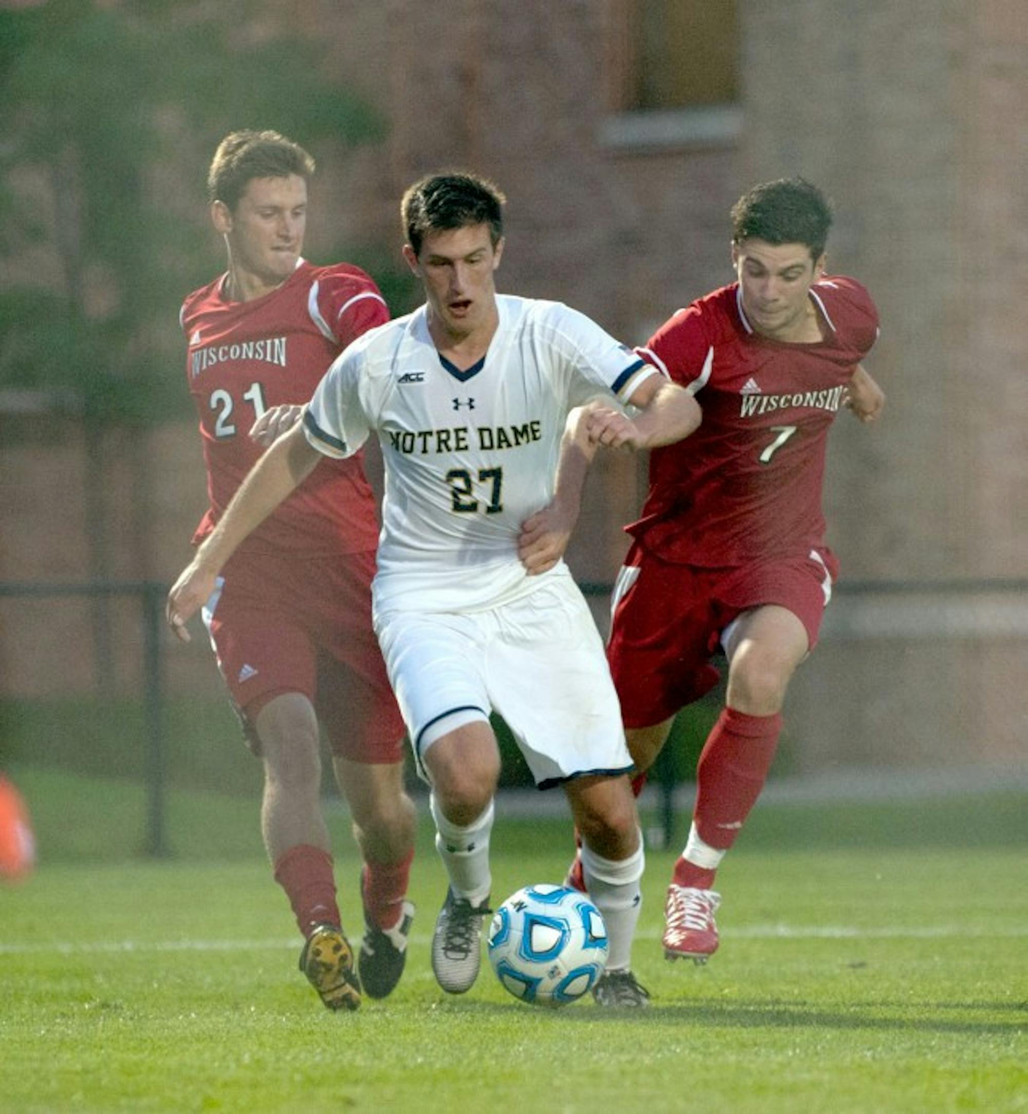Irish junior midfielder Patrick Hodan dribbles between two Wisconsin players in Monday’s 5-1 win over No. 21 Wisconsin. Hodan tallied a goal in the  29th minute and an assist in the match’s 49th minute.