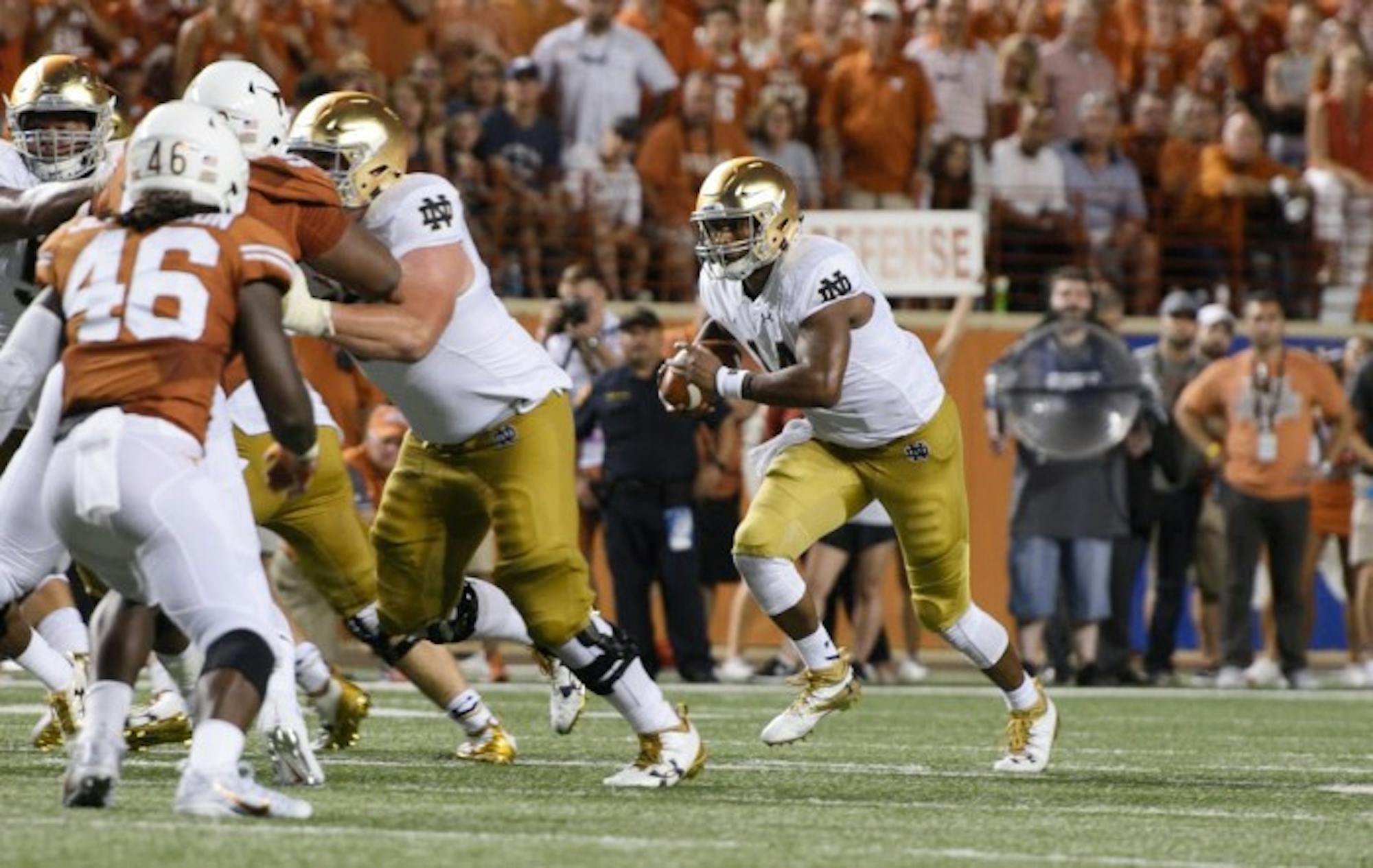 Irish junior quarterback DeShone Kizer tucks the ball and looks for a running lane during Notre Dame’s 50-47 loss to Texas. Kizer had 292 total yards, including 77 on the ground, in Sunday’s defeat.