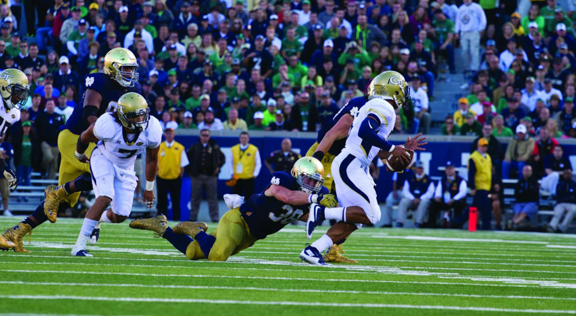 Irish graduate student linebacker Joe Schmidt, right, dives in an attempt to tackle Georgia Tech redshirt junior quarterback Justin Thomas during Notre Dame’s 30-22 win at Notre Dame Stadium on Saturday. Schmidt led the Irish defense with 10 tackles, including two for a loss.