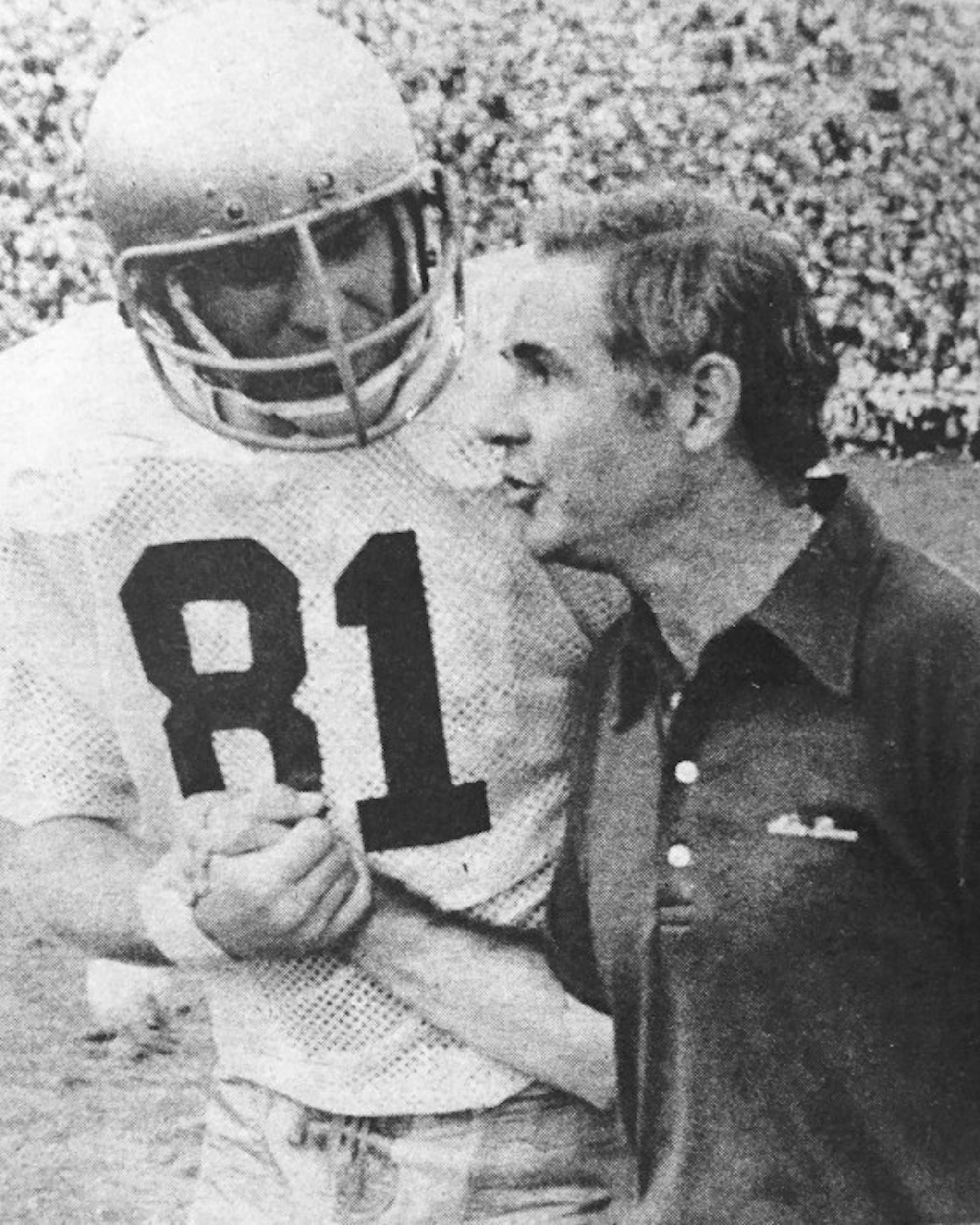 Former Notre Dame tight end Ken MacAfee shakes hands with Irish coach Dan Devine during the 1977 national championship season.