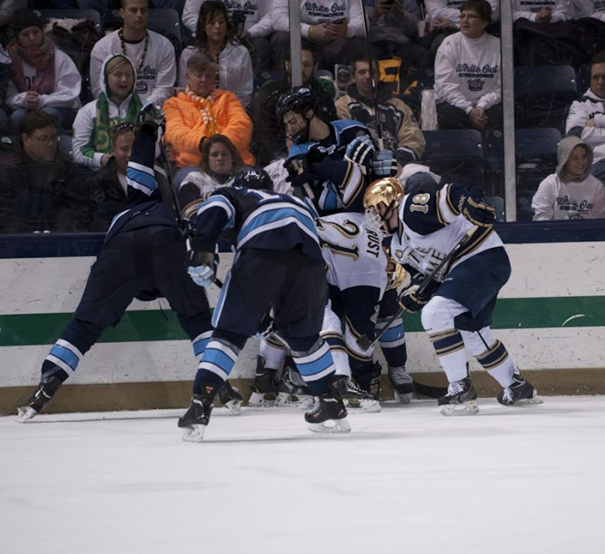 Irish senior forwards T.J. Tynan and Bryan Rust fight for the puck along the boards during  a 2-1 loss to Maine last Friday.