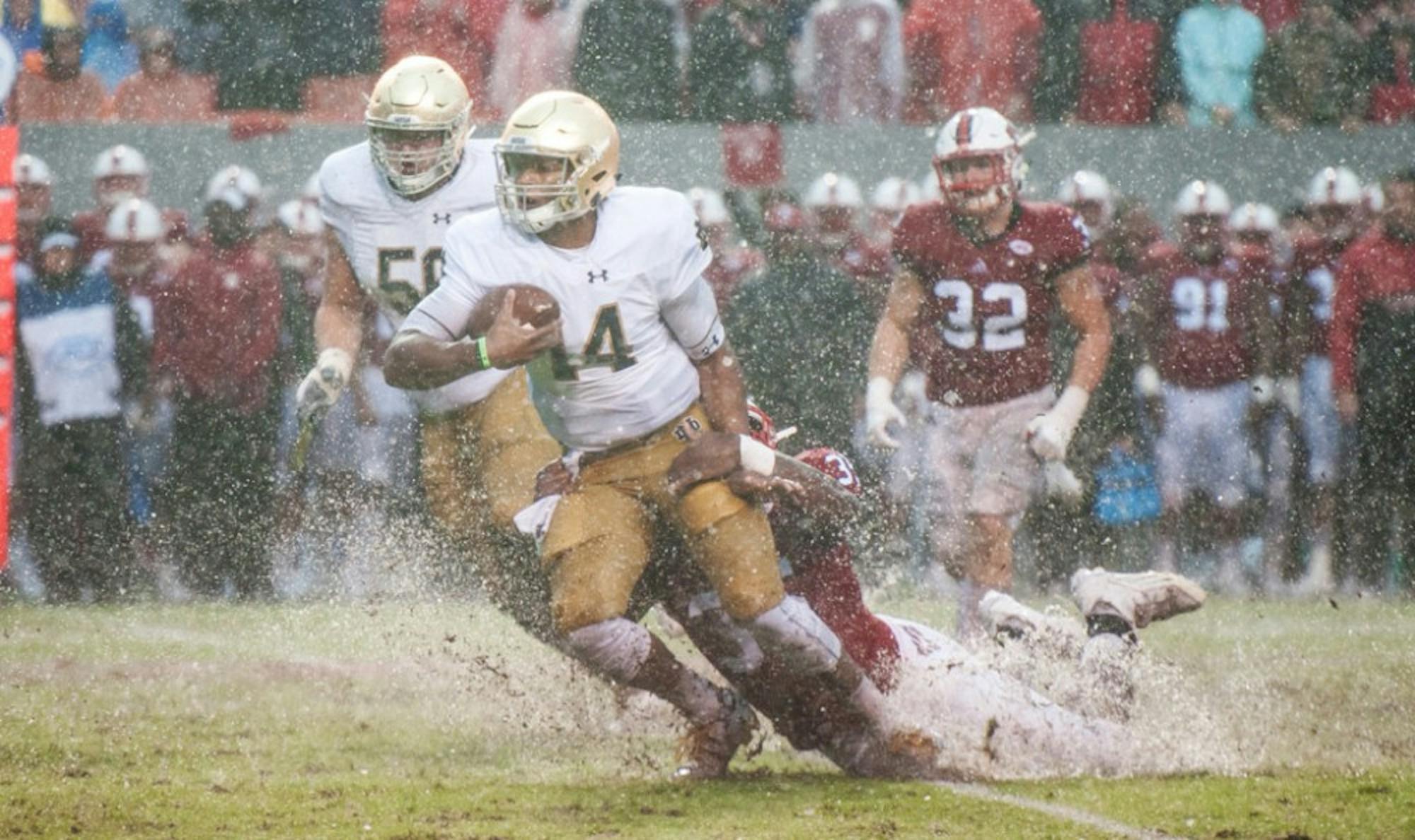 Irish junior quarterback DeShone Kizer is tackled by a North Carolina State defender in one of the puddles that formed at Carter-Finley Stadium as Hurricane Matthew soaked the Raleigh, North Carolina, area.