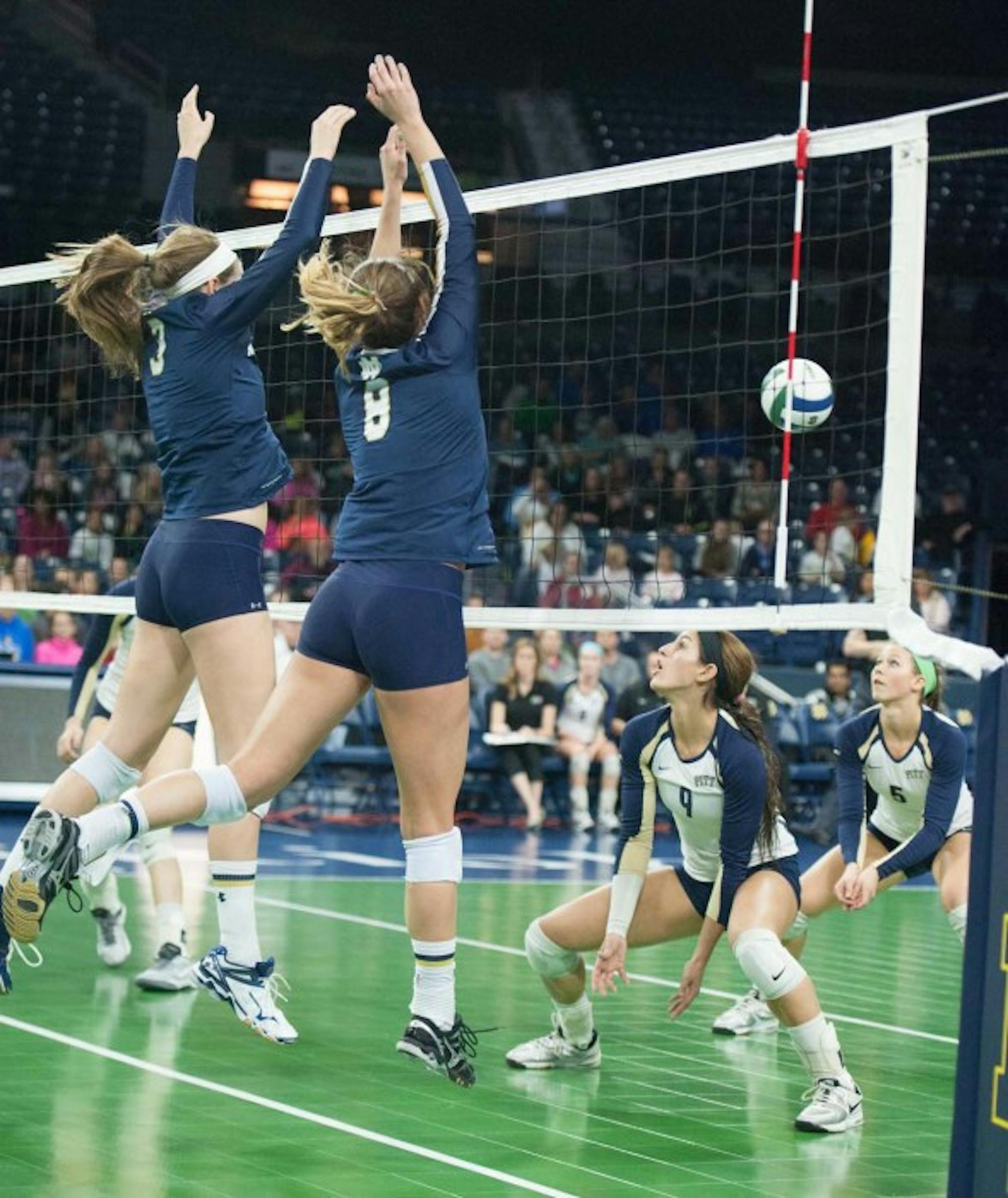 Notre Dame sophomores outside hitter Sam Fry (left) and setter Maddie Dilfer jump during a 3-0 loss to Pittsburgh on Nov. 28 at Purcell Pavilion.