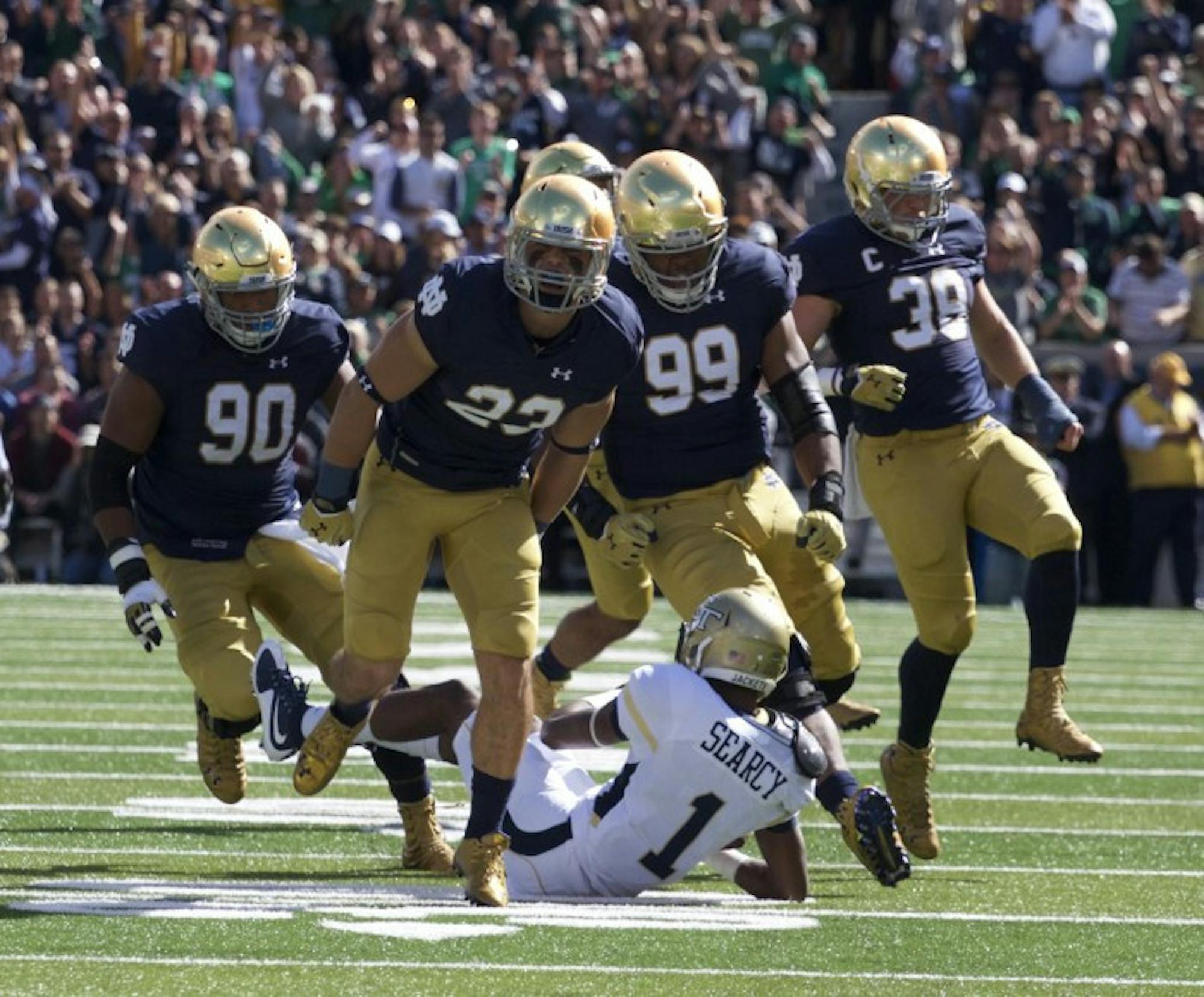 Flanked by his teammates, sophomore safety Drue Tranquill celebrates a third-down stop Saturday.