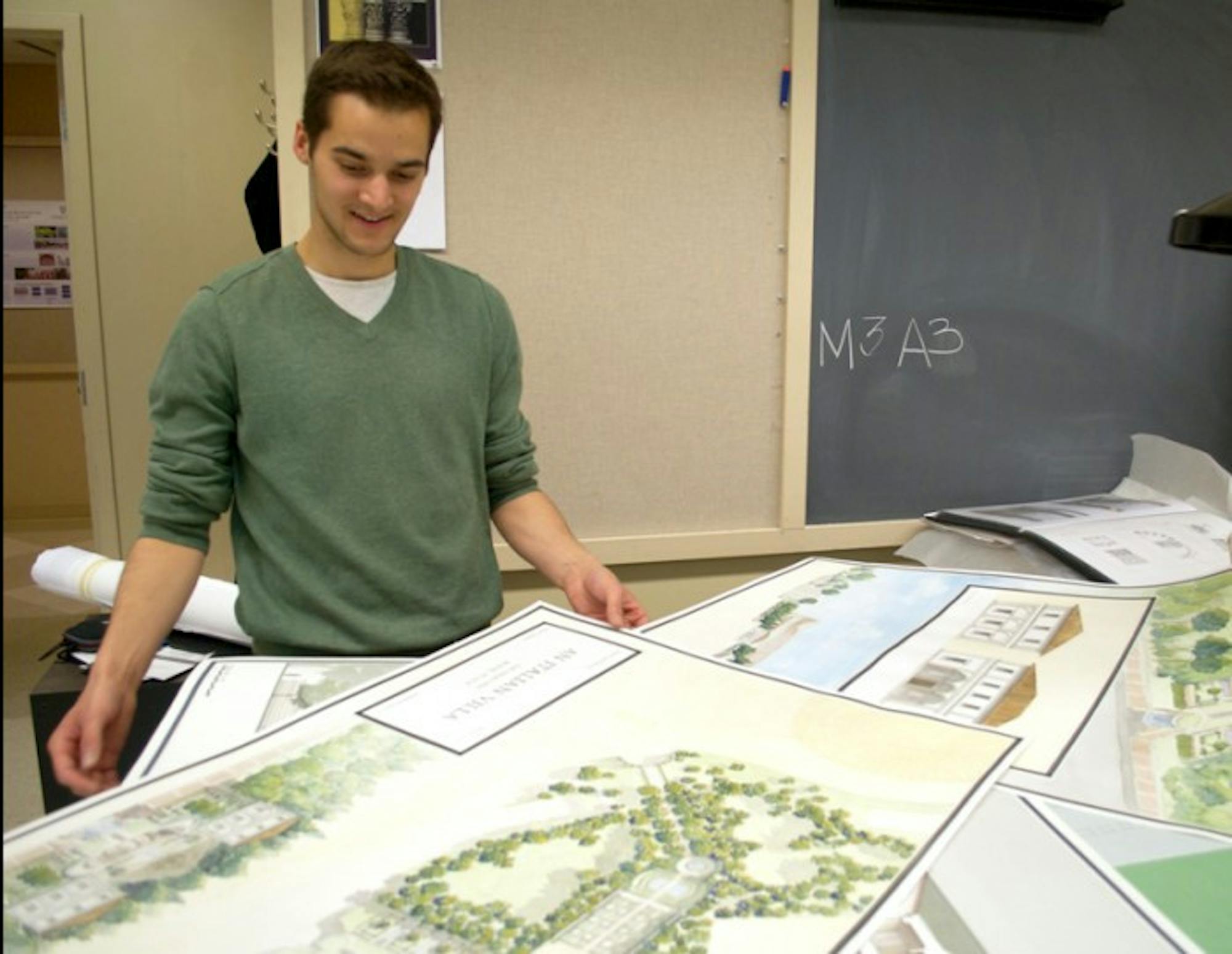 Fifth-year architecture student Mark Santrach reviews reprints of watercolors he created for class projects while studying abroad in Rome. Santrach earned a 3.993 cumulative grade point average at Notre Dame.