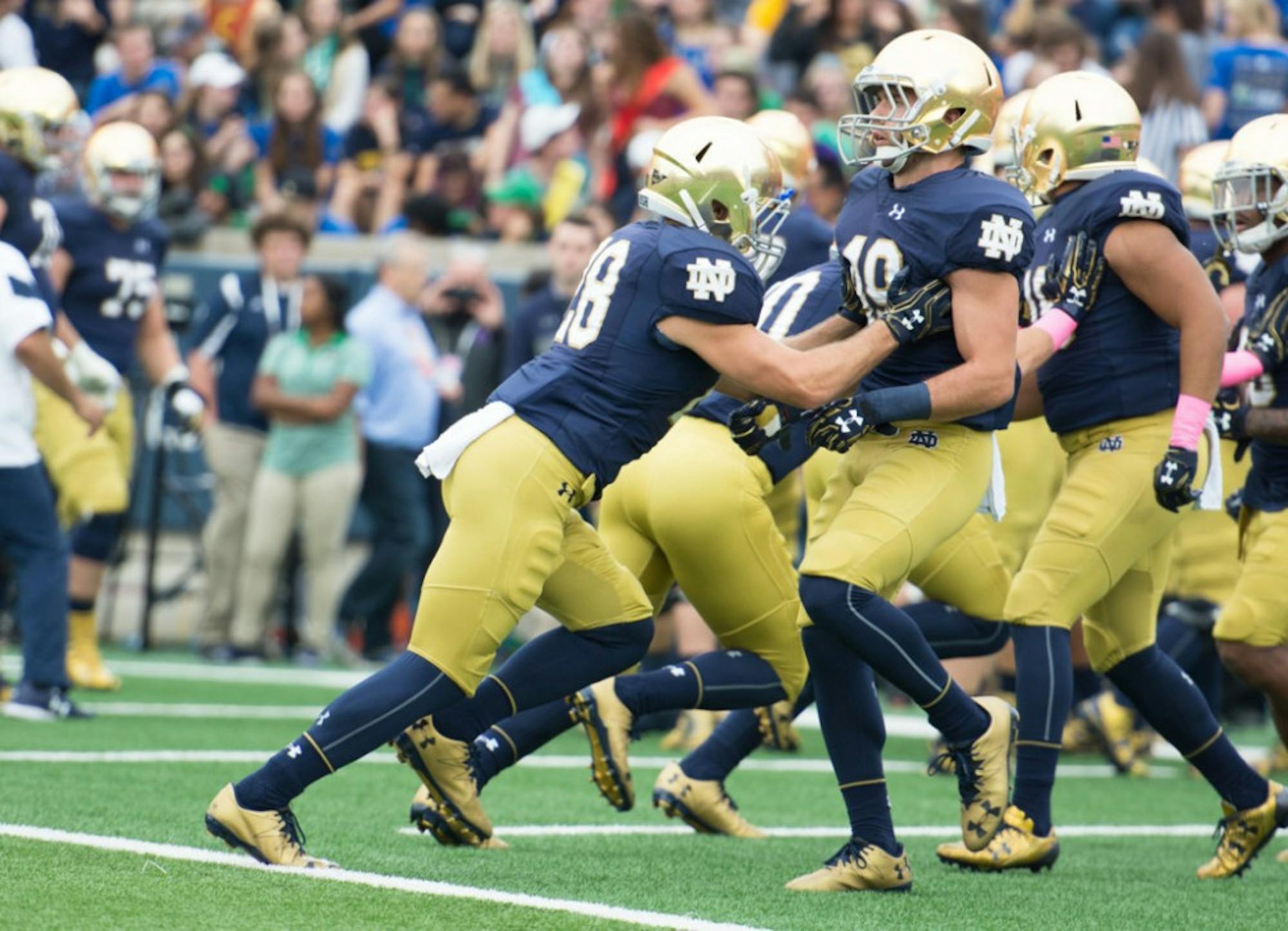 Irish senior running back Austin Ross warms up with a teammate before Notre Dame’s victory over Miami on Oct. 29.