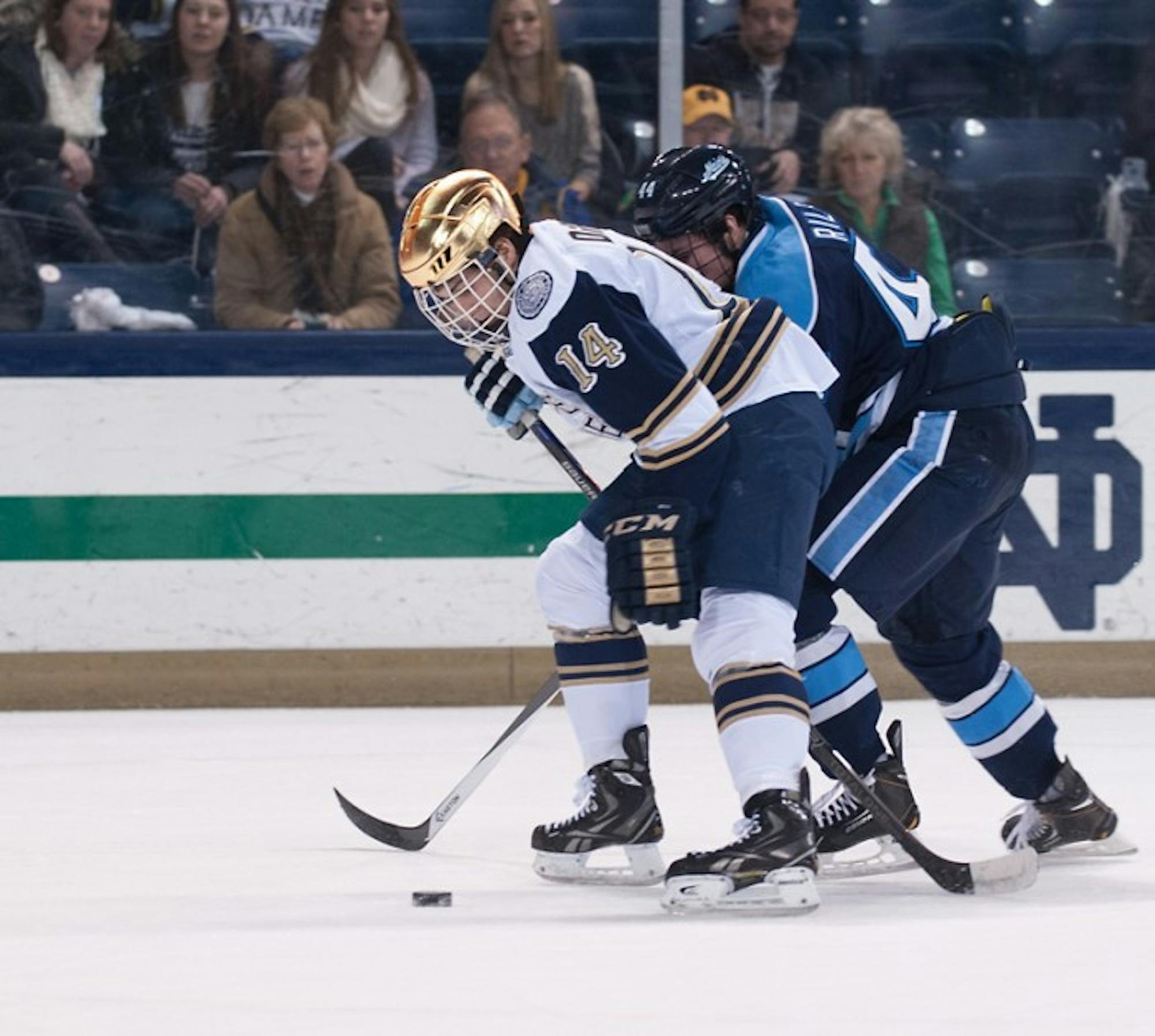 Irish sophomore forward Thomas DiPauli fights for the puck during a game versus Maine on Feb. 7. DiPauli scored a goal in Saturday's 4-3 overtime loss.