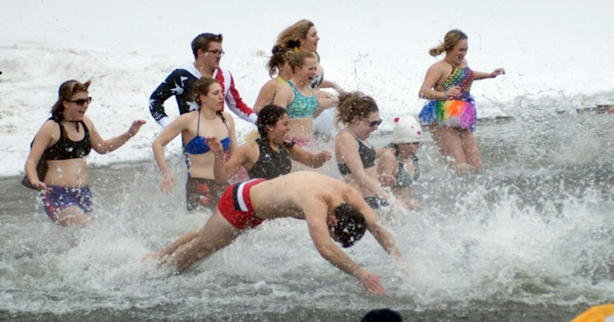 Students plunge into the icy cold water of Saint Joseph’s Lake at last year’s Polar Bear Plunge.