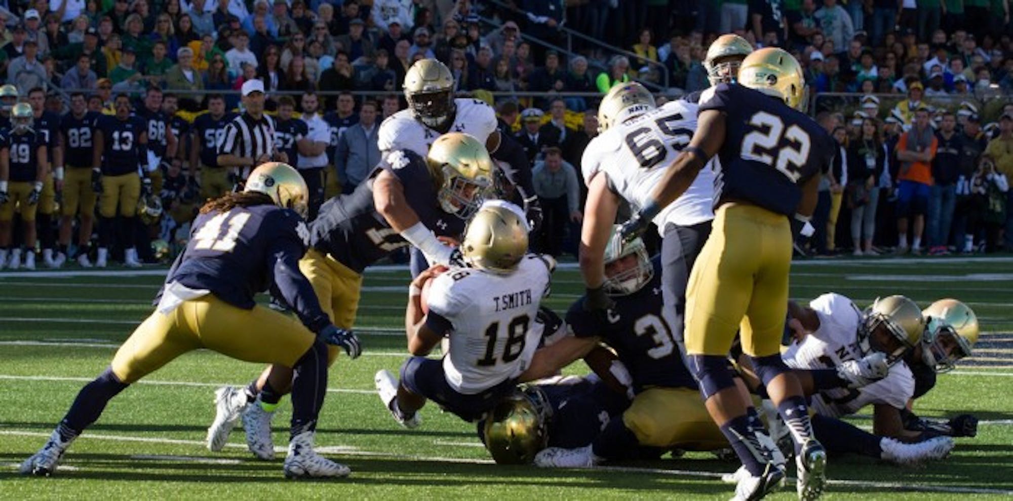 Graduate student cornerback Matthias Farley, 41, and senior safety Elijah Shumate, 22, get in on a tackle during Notre Dame’s 41-24 win over Navy last Saturday at Notre Dame Stadium.