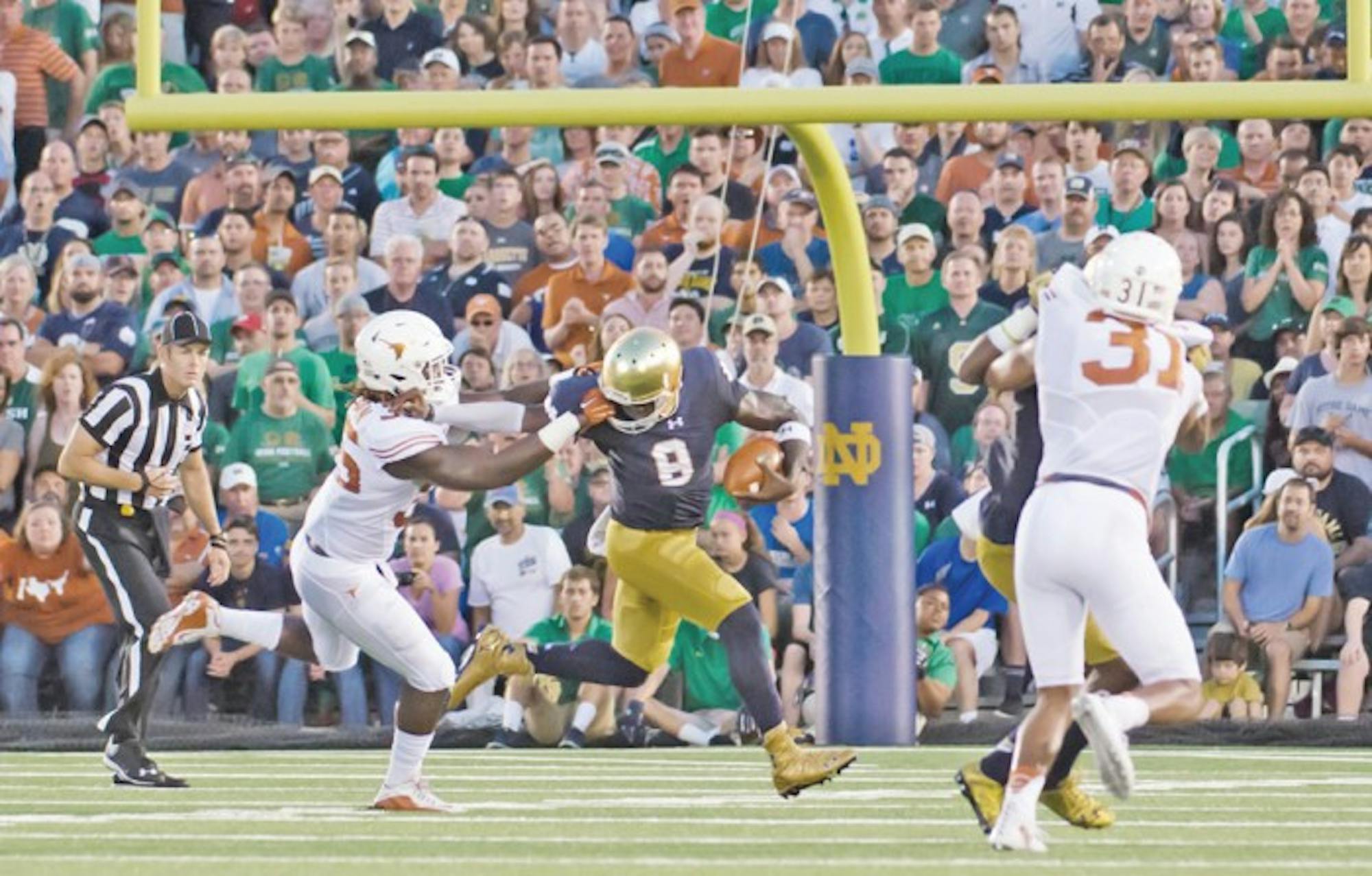 Irish senior quarterback Malik Zaire stiff arms a defender during Notre Dame’s 38-3 win over Texas on Sept. 5 at Notre Dame Stadium. Zaire threw for 313 yards in the Irish rout.