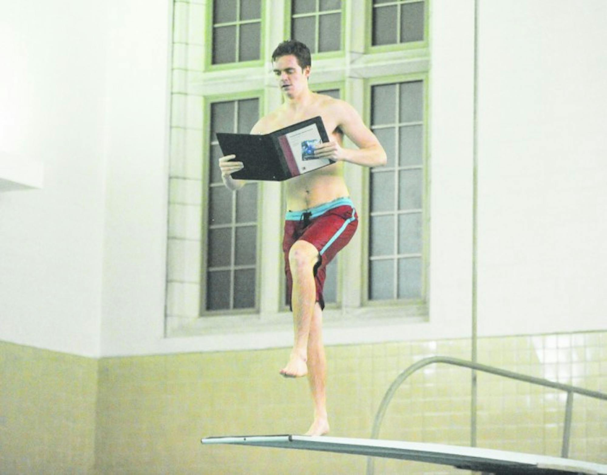 Sophomore Jack Waltrich prepares to jump off a Rockne Memorial diving board while pretending to study as part of the dorm’s event.