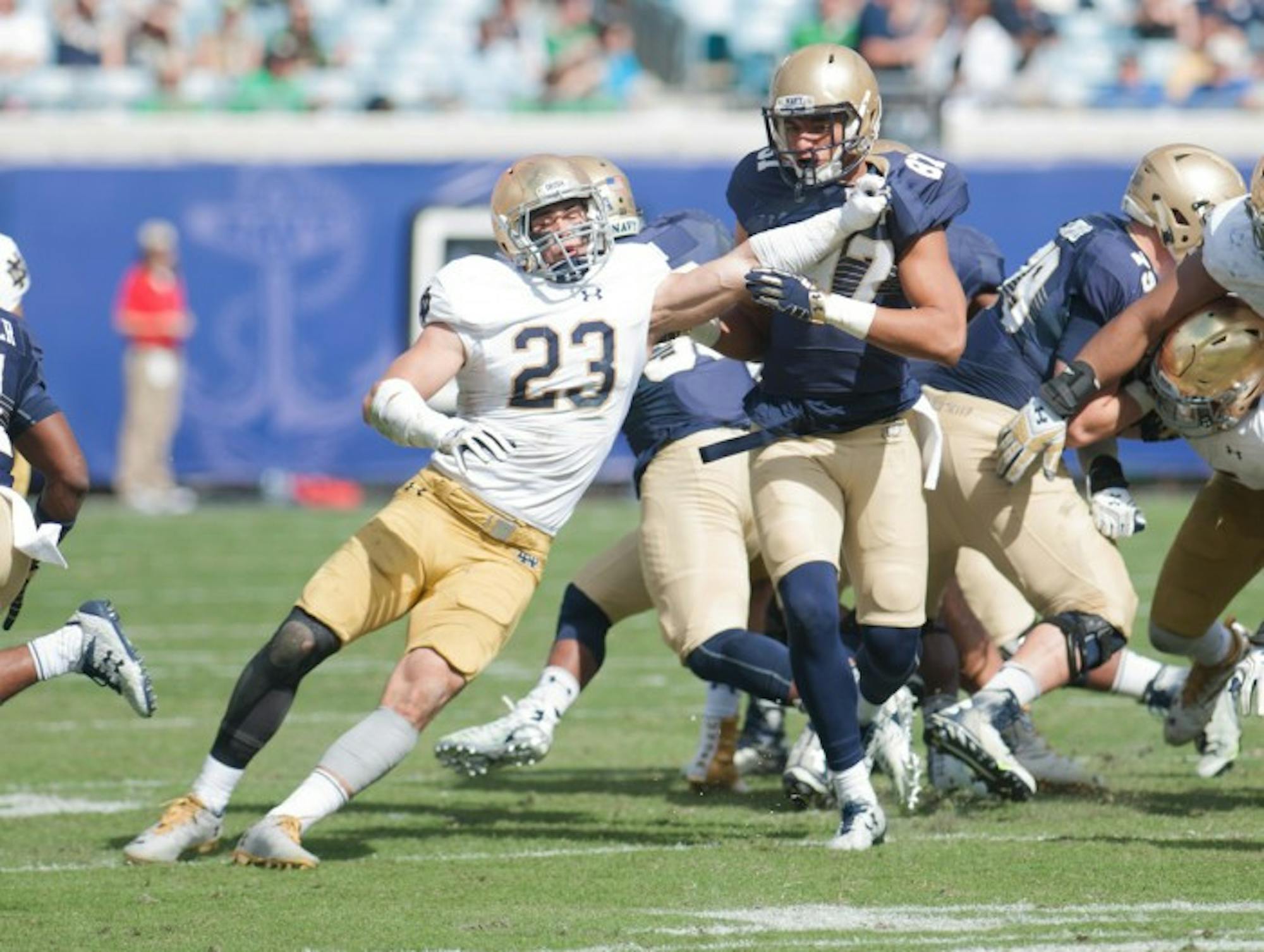 Irish junior safety Drue Tranquill fights through a block during Notre Dame’s 28-27 loss to Navy on Saturday at EverBank Field.