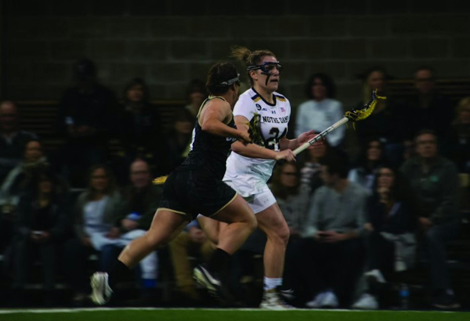 Irish junior midfielder Casey Pearsall carries the ball down the field during Notre Dame’s 14-4 win over Colorado on Friday at Loftus Sports Center. Pearsall had a goal and two assists in the Irish victory.