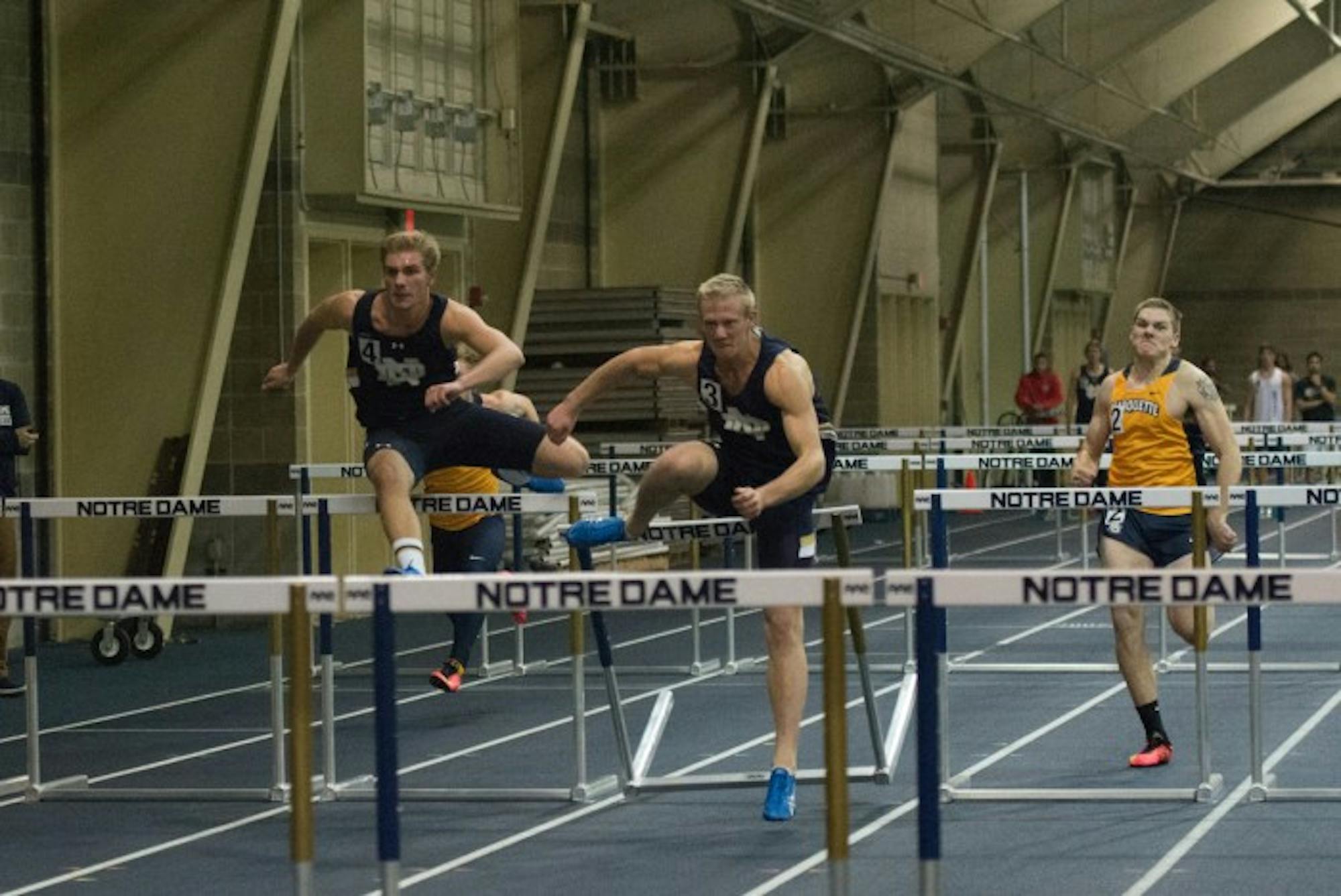 Irish junior Brent Swanberg, center, storms through the 60-meter hurdles during the Blue and Gold Invitational on Dec. 5.