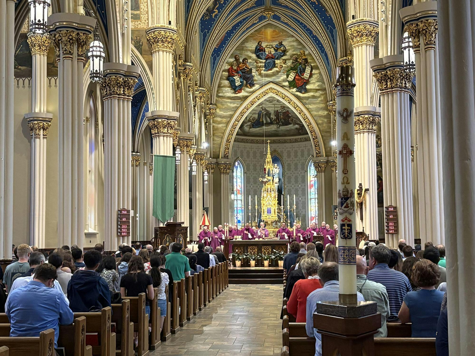 Basilica of the Sacred Heart with 150 members of the congregation present and 25 priests dressed in purple vestments near the alter during the consecration. 