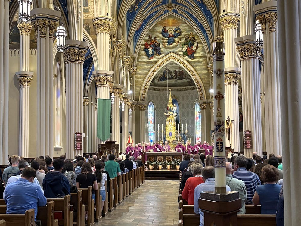 Basilica of the Sacred Heart with 150 members of the congregation present and 25 priests dressed in purple vestments near the alter during the consecration. 