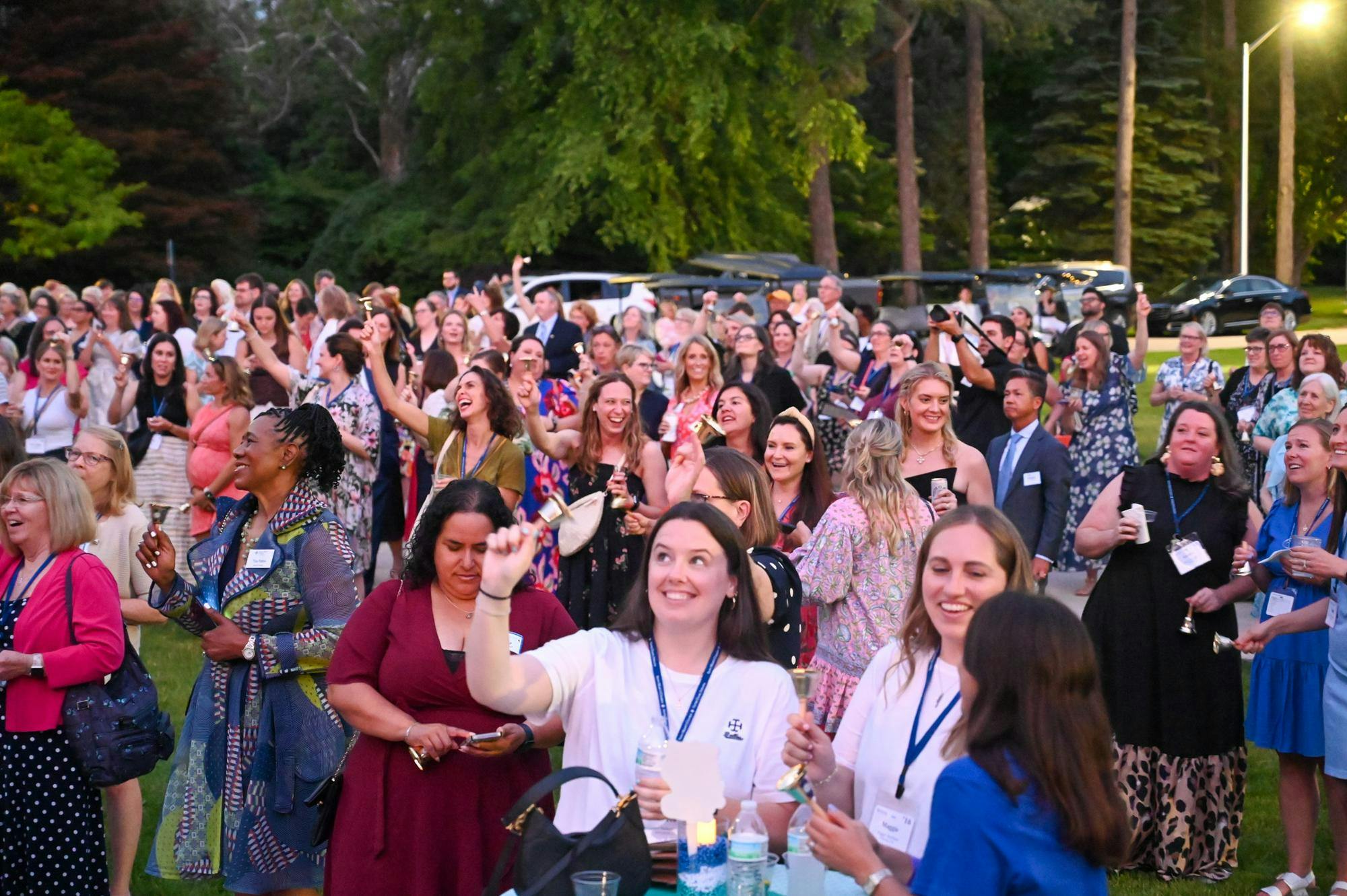 Alumnae seen cheering with bells during the unveil