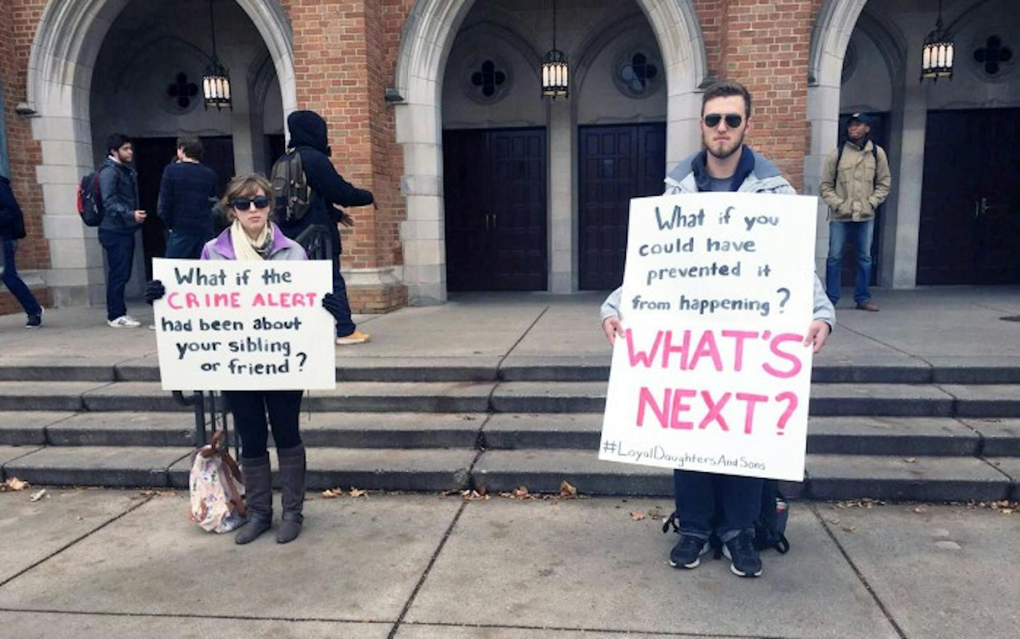 Seniors Tess Rinaldo, left, and Skyler Hughes hold signs outside of South Dining Hall to raise awareness for sexual assault and rape culture as part of Loyal Daughters and Sons’ “Talk About it Tuesday” campaign.