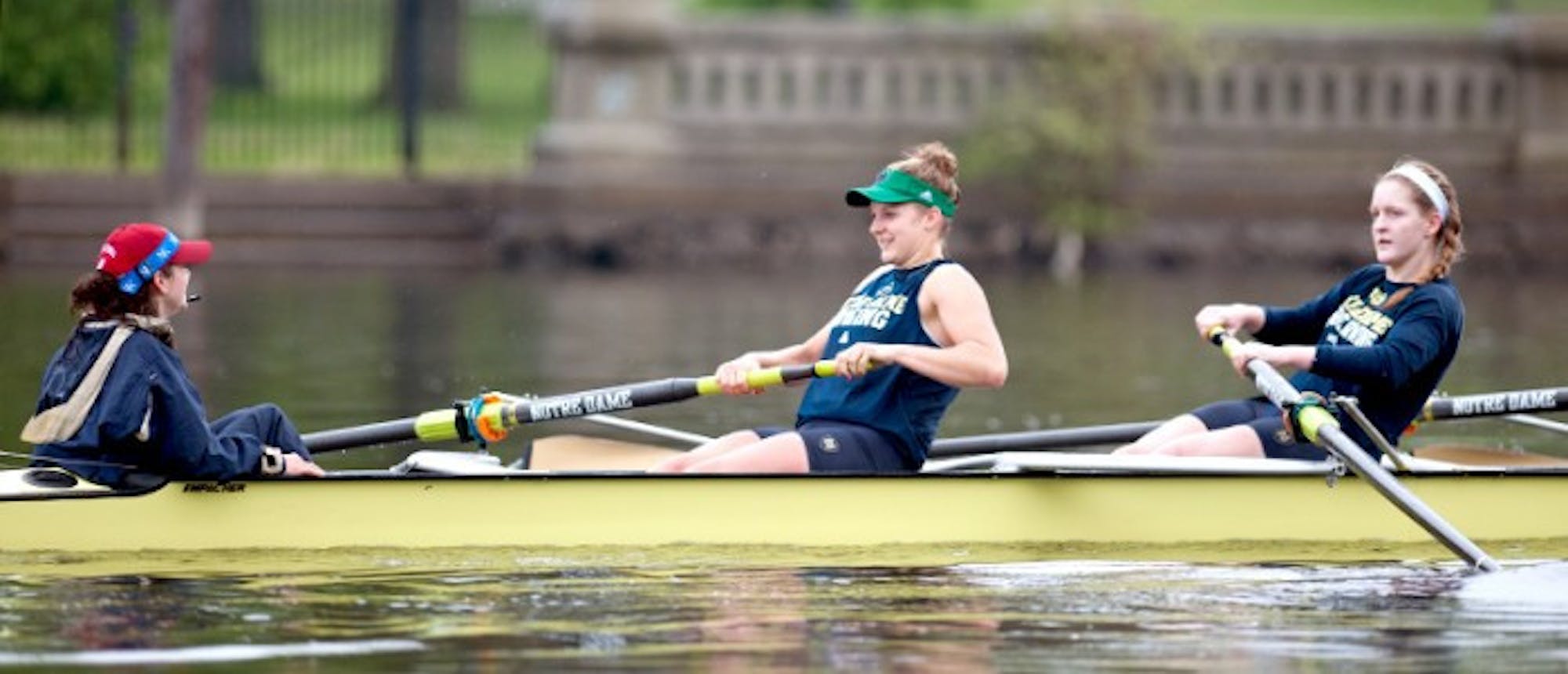Senior Molly Bruggeman and junior Erin Boxberger sroke down the river as senior coxswain Christina Dines leads the crew in practice on April 25.