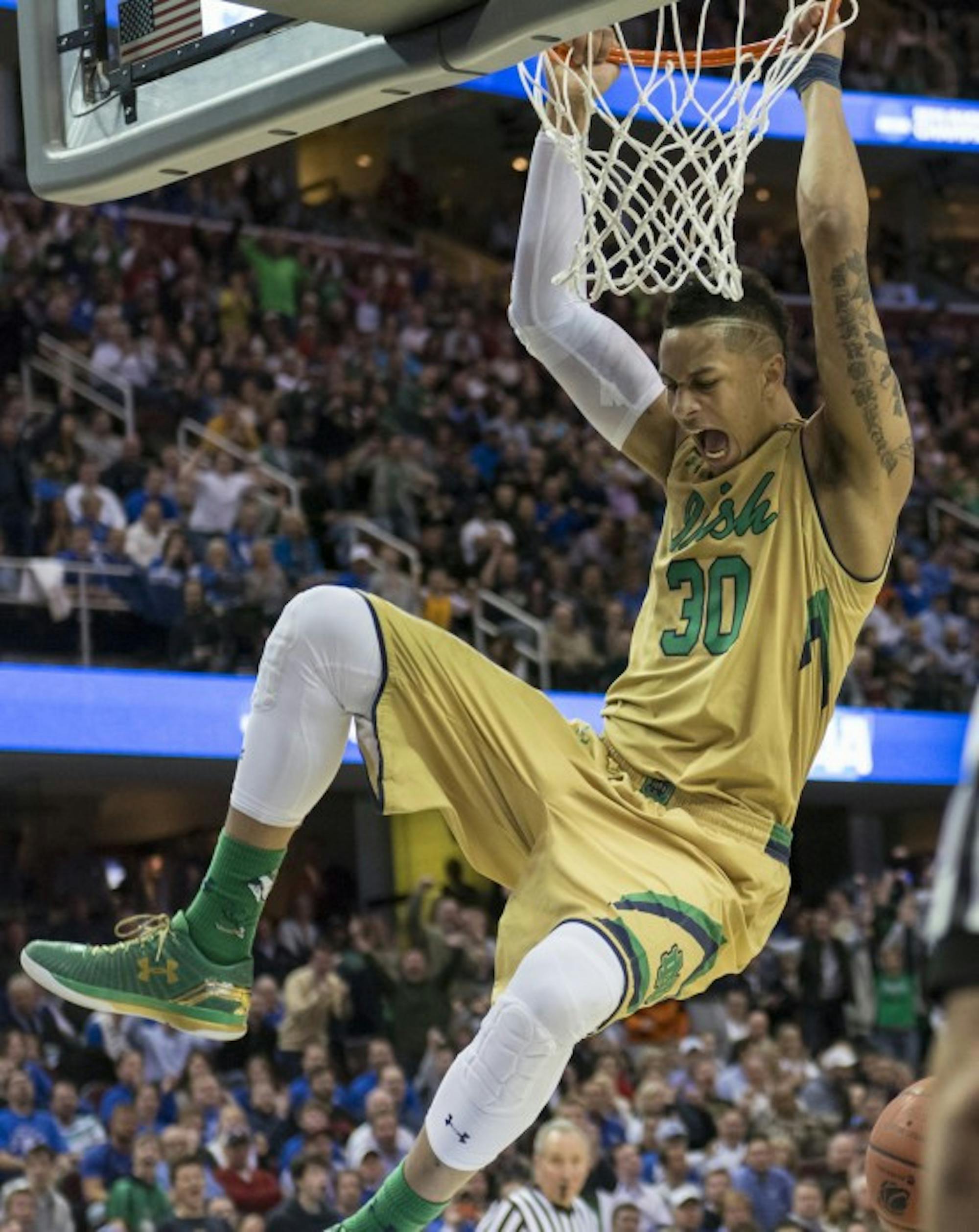 Senior forward Zach Auguste hangs on the rim in a 68-66 loss to Kentucky in the regional finals of the 2015 NCAA Tournament.