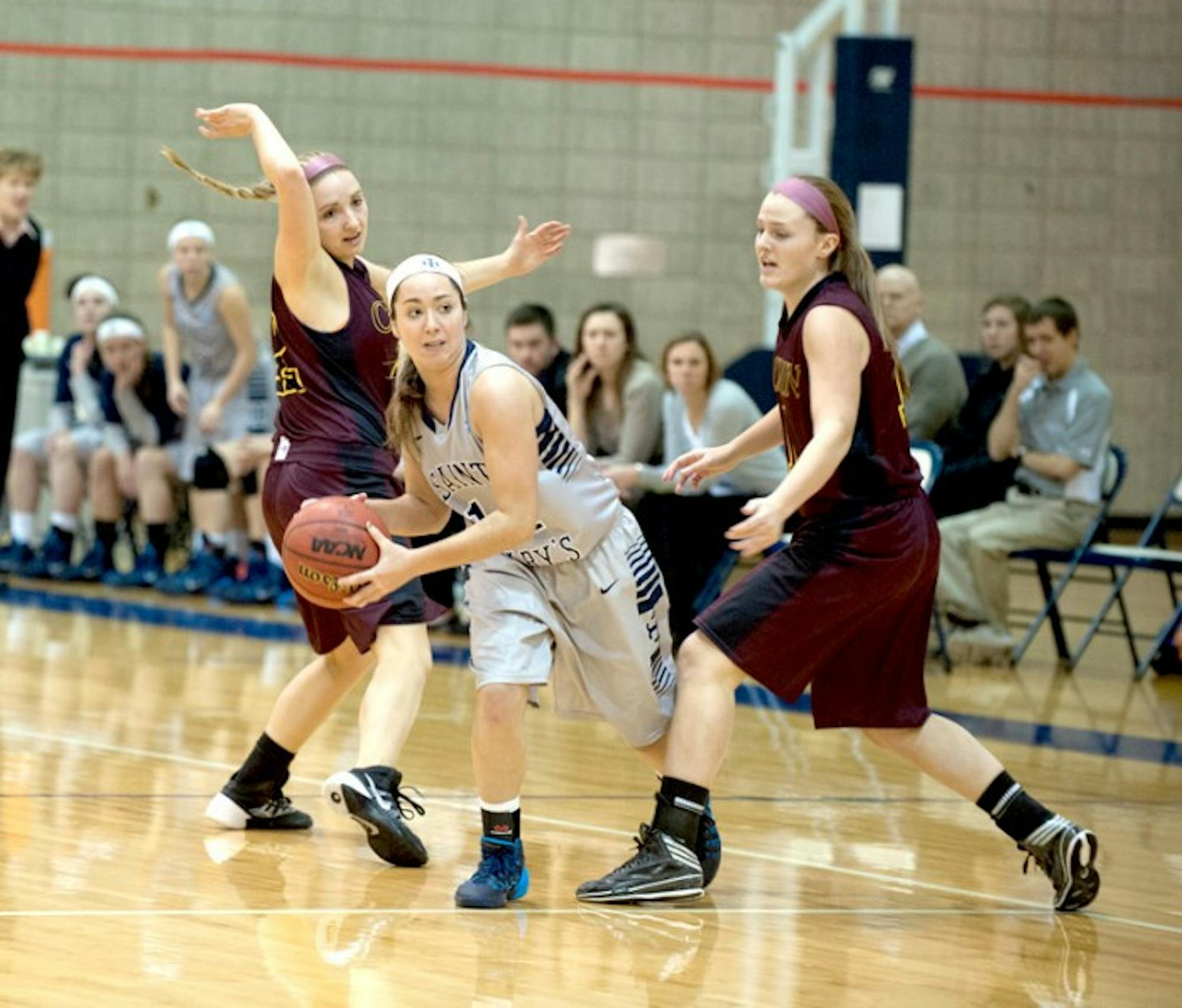 Saint Mary's freshman point guard Kristen Kleist looks to pass while avoiding two defenders during 95-68 loss to Calvin on Jan. 15.