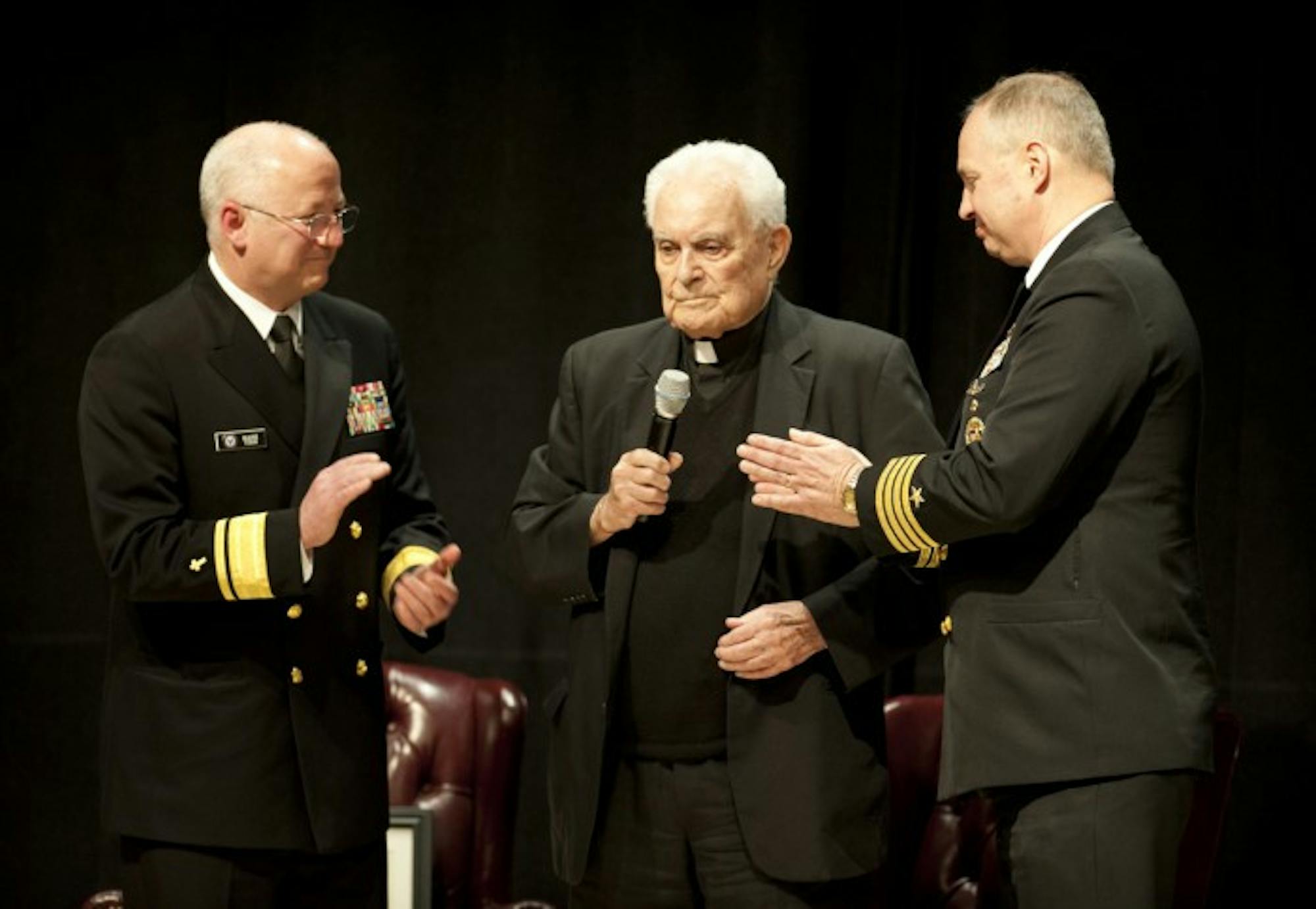 Fr. Theodore Hesburgh, center, speaks during his ceremony to become an honorary naval chaplain on April 17, 2013. Rear Admiral Mark Tidd, chief of U.S. Navy chaplains, stands to Hesburgh's left, and Captain Earl Carter, then-commanding officer of Notre Dame's Navy Reserve Officer Training Corps, stands to his right.