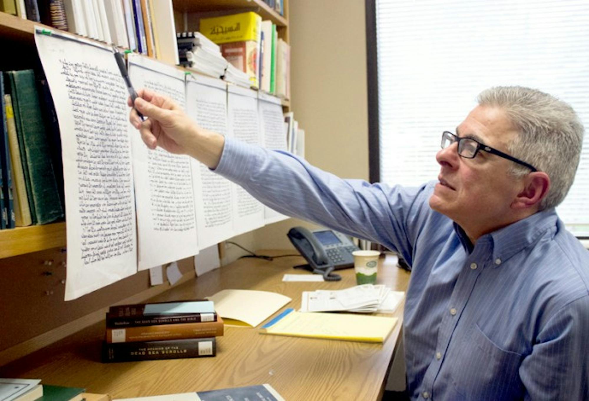 Classics professor Joseph Amar examines a copy of the commentary of the Book of Genesis by Jacob of Edessa. Amar said he believes this manuscript was published in the third century.