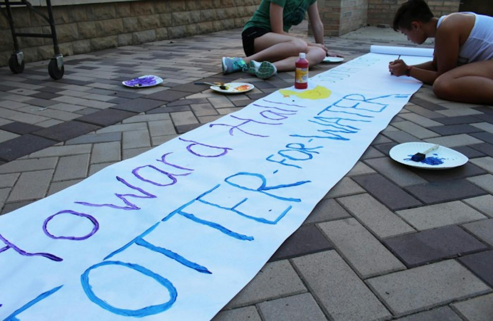 Howard Hall residents paint a banner for their signature event, Totter for Water. The event benefits Engineers Without Borders, an organization that works on sustainability issues.