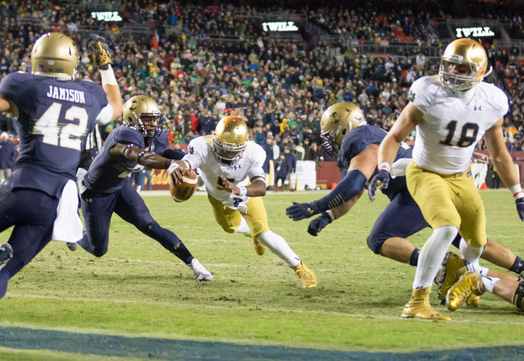 Irish senior quarterback Everett Golson dives forward for a fourth-quarter rushing touchdown to put Notre Dame back ahead en route to its 49-39 win over Navy on Saturday in Landover, Maryland.