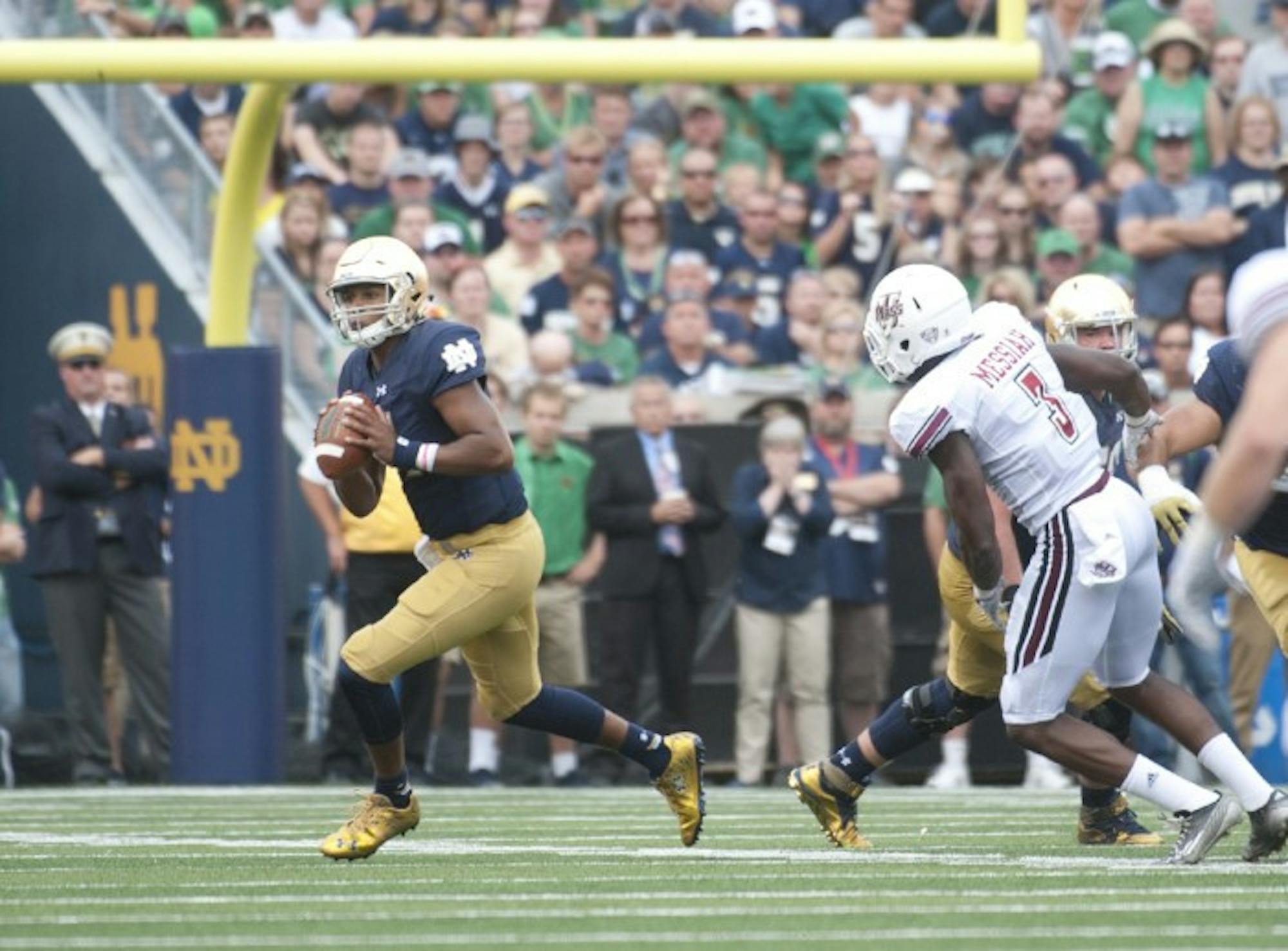 Irish freshman quarterback Brandon Wimbush rolls out to pass during his Notre Dame debut Saturday. Wimbush ran for a touchdown, the first in his Irish career, and had a deep pass to junior receiver Will Fuller, his first attempt, ruled incomplete after a video review. Wimbush also had a would-be touchdown pass called back due to an Irish penalty.