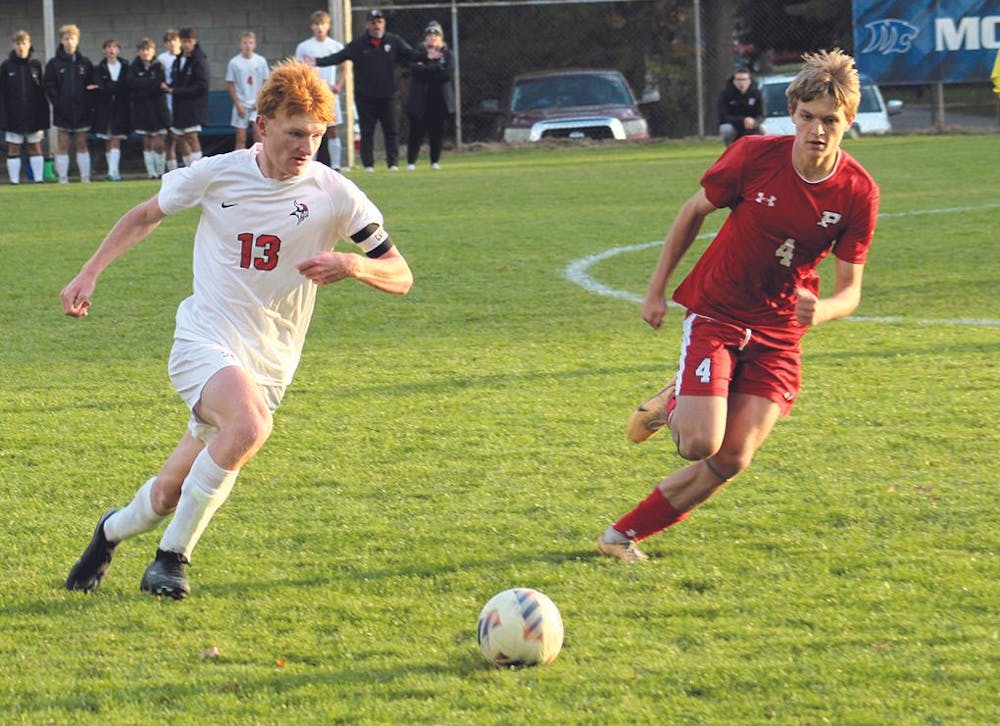 Whitehall's Tyler Van Antwerp (left) and Fremont's Redick Powell pursue a loose ball during Monday's district semifinal at Montague. The Packers won the game, 3-0.