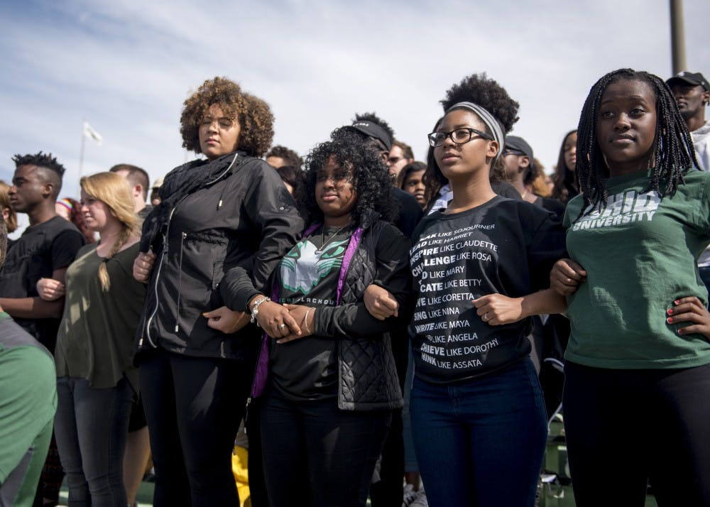 Members of EPIC (Enforce, Protect, Include, and Create) stand with their arms linked during the national anthem during the Homecoming football game on Saturday, Octobr 8, 2016. (CARL FONTICELLA | PHOTO EDITOR)