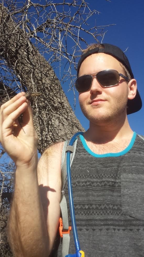 Anthony Gilbert, a fourth year doctorate student, poses with a reptile.