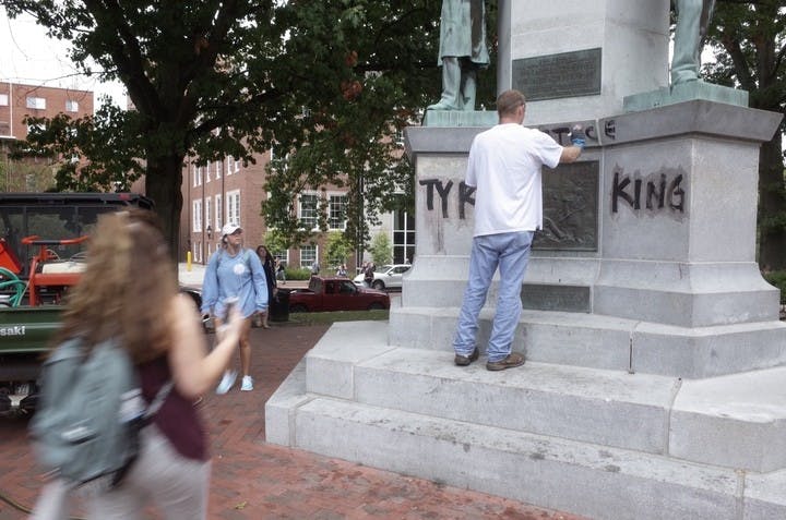 A man works to cover up "Justice 4 Tyre King"&nbsp;graffiti that appeared Monday morning.&nbsp;