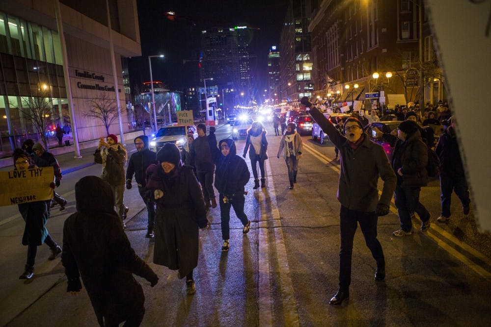 Protesters march through the street near the Franklin County Courthouse during a&nbsp;Resist Trump Rally in Columbus on Monday, Jan. 30, 2017.