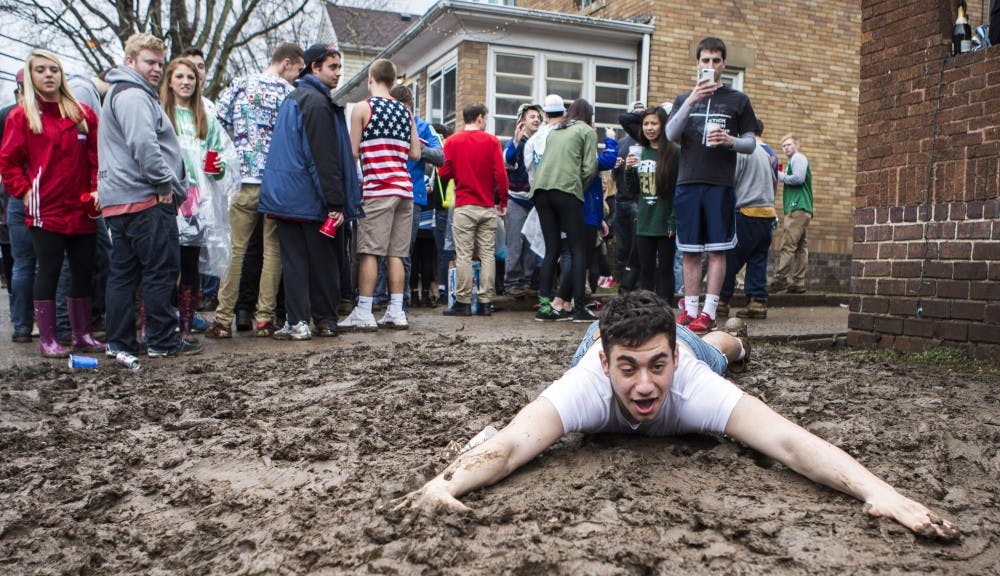 Blaine Levin slides through the mud in the front yard of a Mill Street house during Mill Fest. (PATRICK CONNOLLY | STAFF PHOTOGRAPHER)