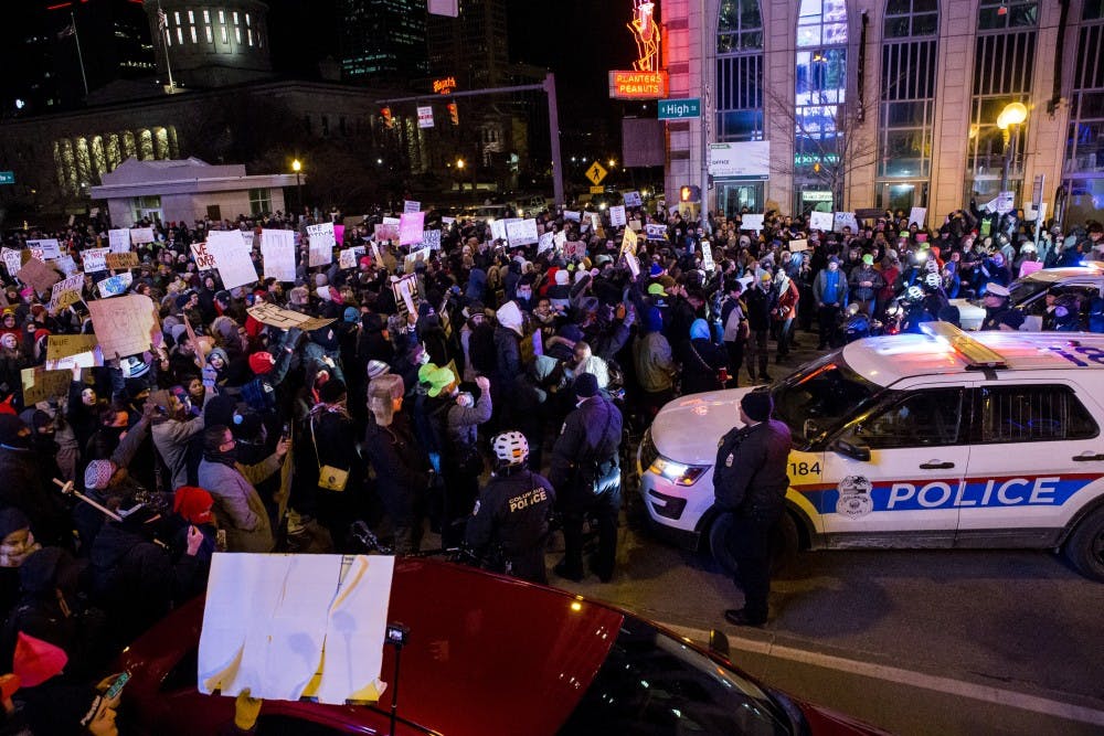 Police stand by while protesters block the intersection of South High and State streets in Columbus&nbsp;during a Resist Trump Rally in Columbus on Monday, Jan. 30, 2017.