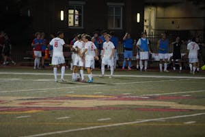 5 soccer players are standing on the field and 17 more are on the sidelines