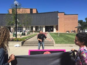 Created Equal organizer explains his stance as student protesters listen while covering a sign which displayed graphic images with a bed sheet.