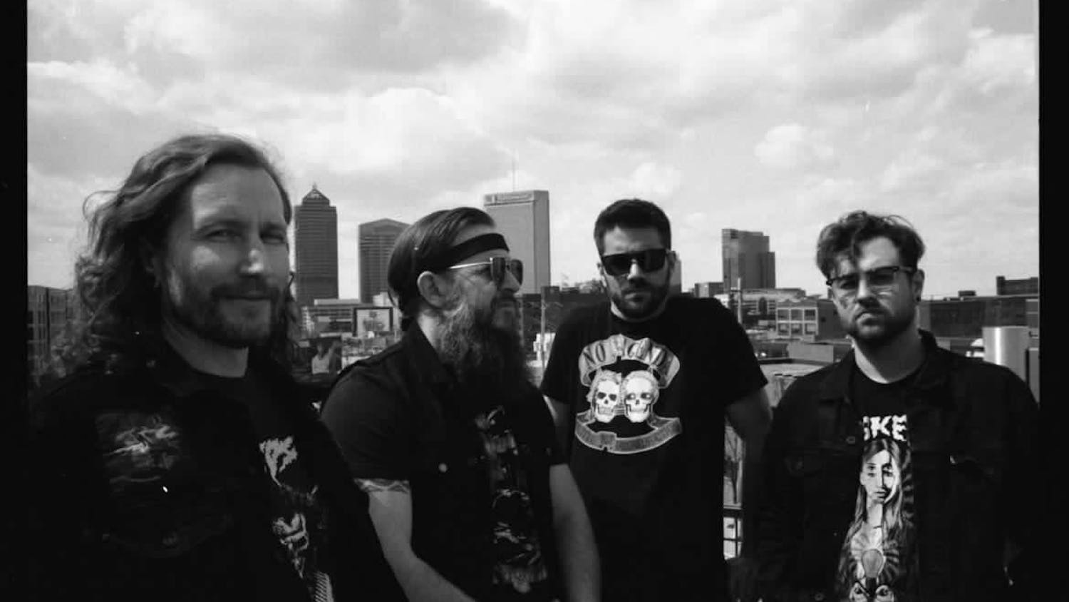 All four members of Denim Cobra band, posing in front of the Columbus Skyline for a group photo.